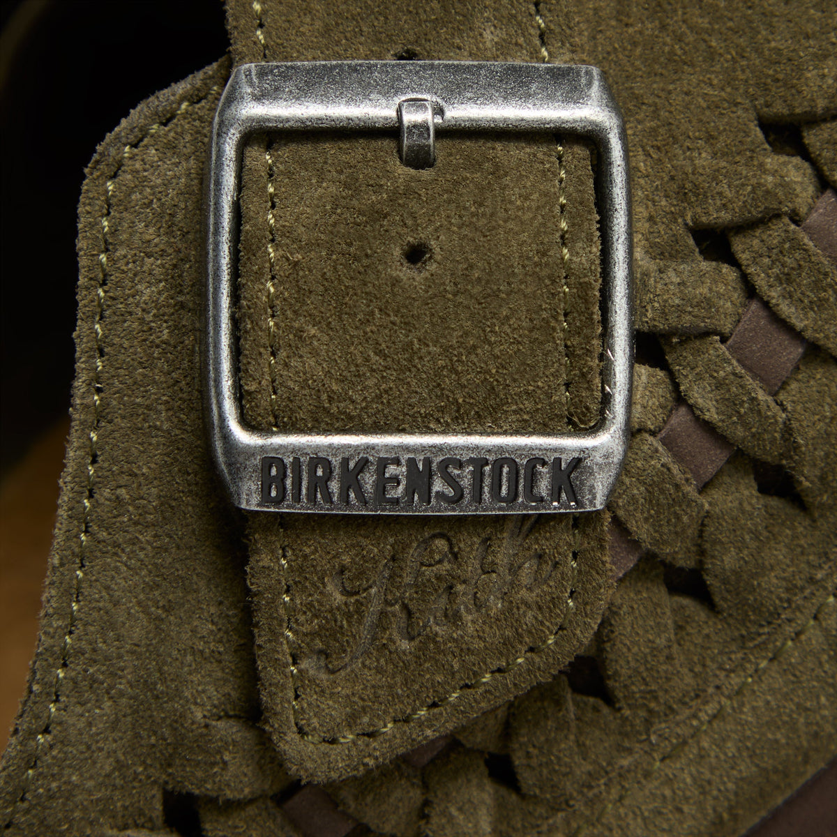 Kith for Birkenstock Boston Braided in Thyme, macro of the silver buckle embossed Birkenstock with Kith script in olive suede
