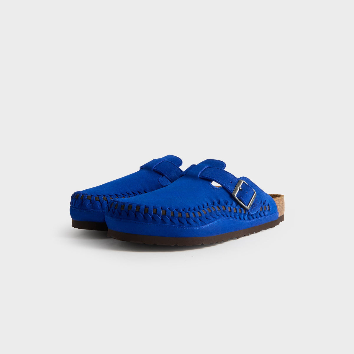 Kith for Birkenstock Women's Boston Braided in Ultra Blue, front three-quarter view of the cobalt suede clog pair with braided toe edges