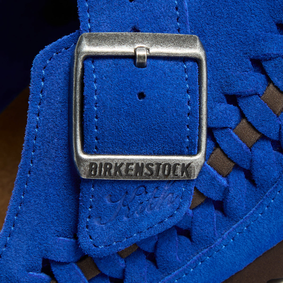 Kith for Birkenstock Women's Boston Braided in Ultra Blue, macro of the silver buckle embossed Birkenstock with Kith script in cobalt suede