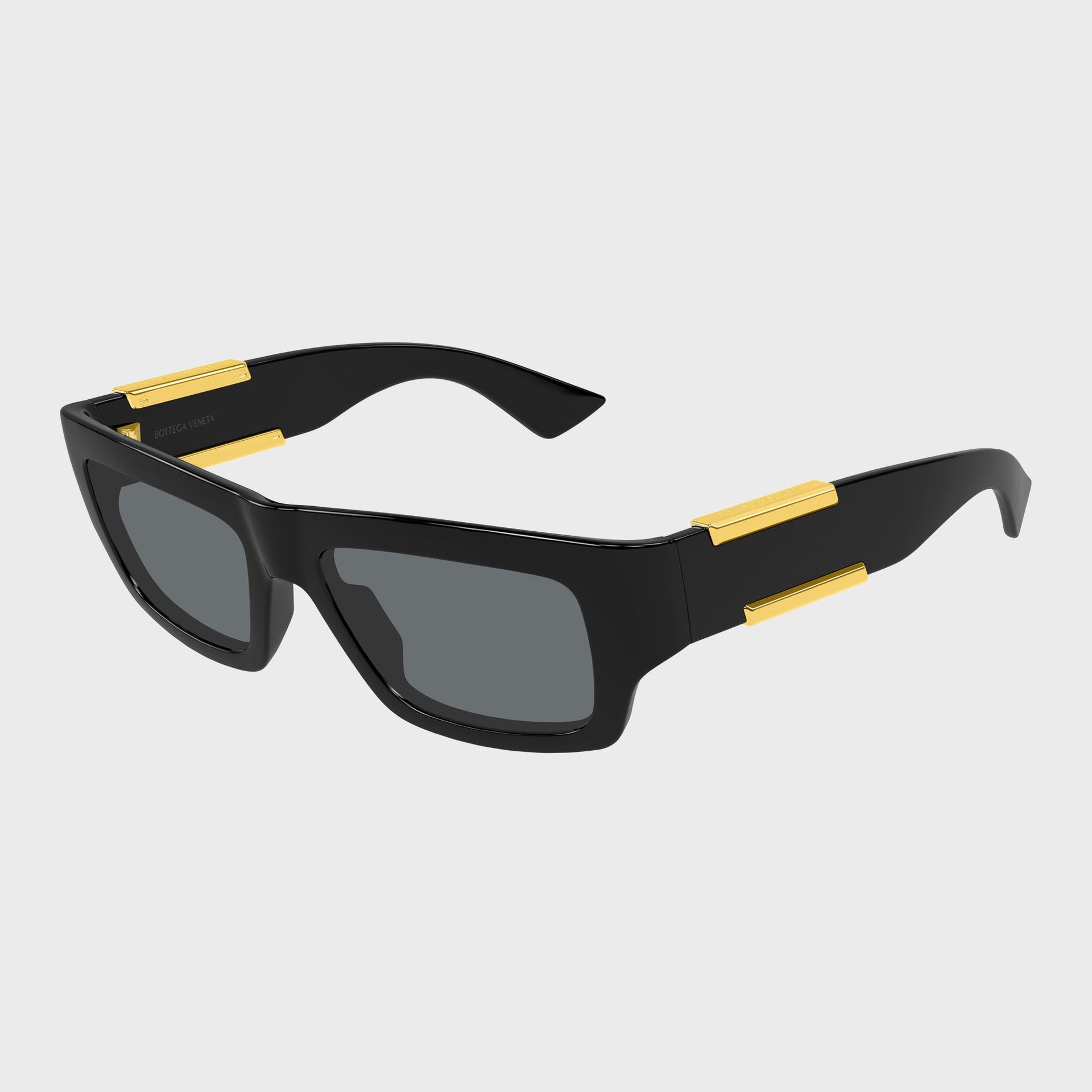 Bottega Veneta Dash rectangular sunglasses in black, three-quarter view with gold bar temple accents