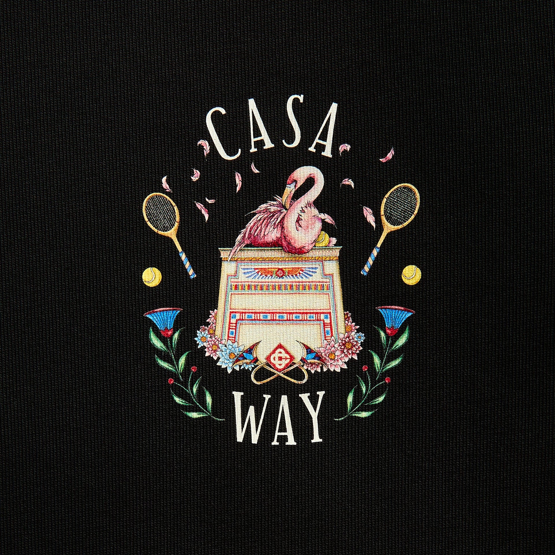 Close-up of Casa Way crest: pink flamingos on an Egyptian pedestal with crossed tennis rackets, balls and flowers