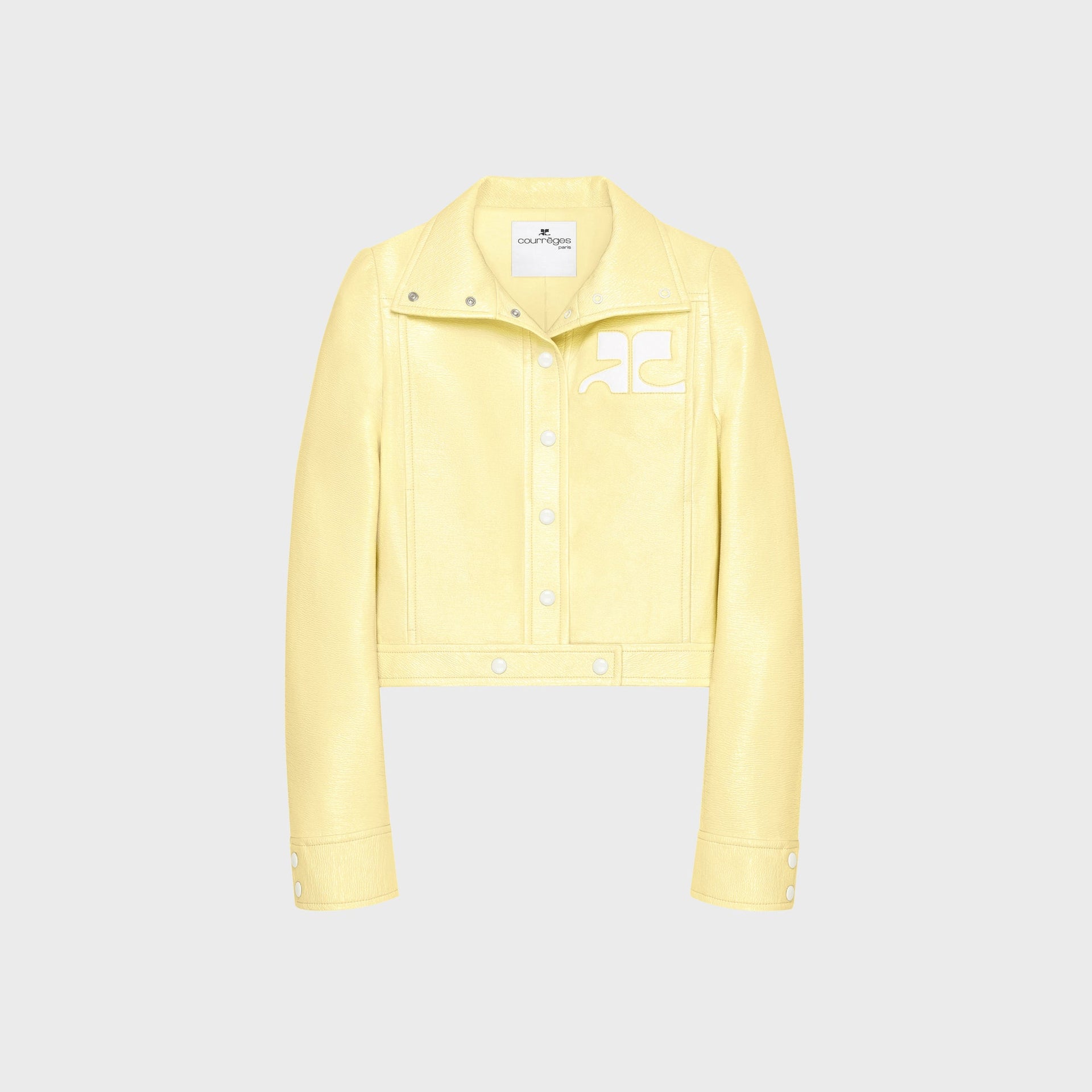 Courreges pale yellow ReEdition vinyl jacket with snap placket and white logo patch, front view, flat lay