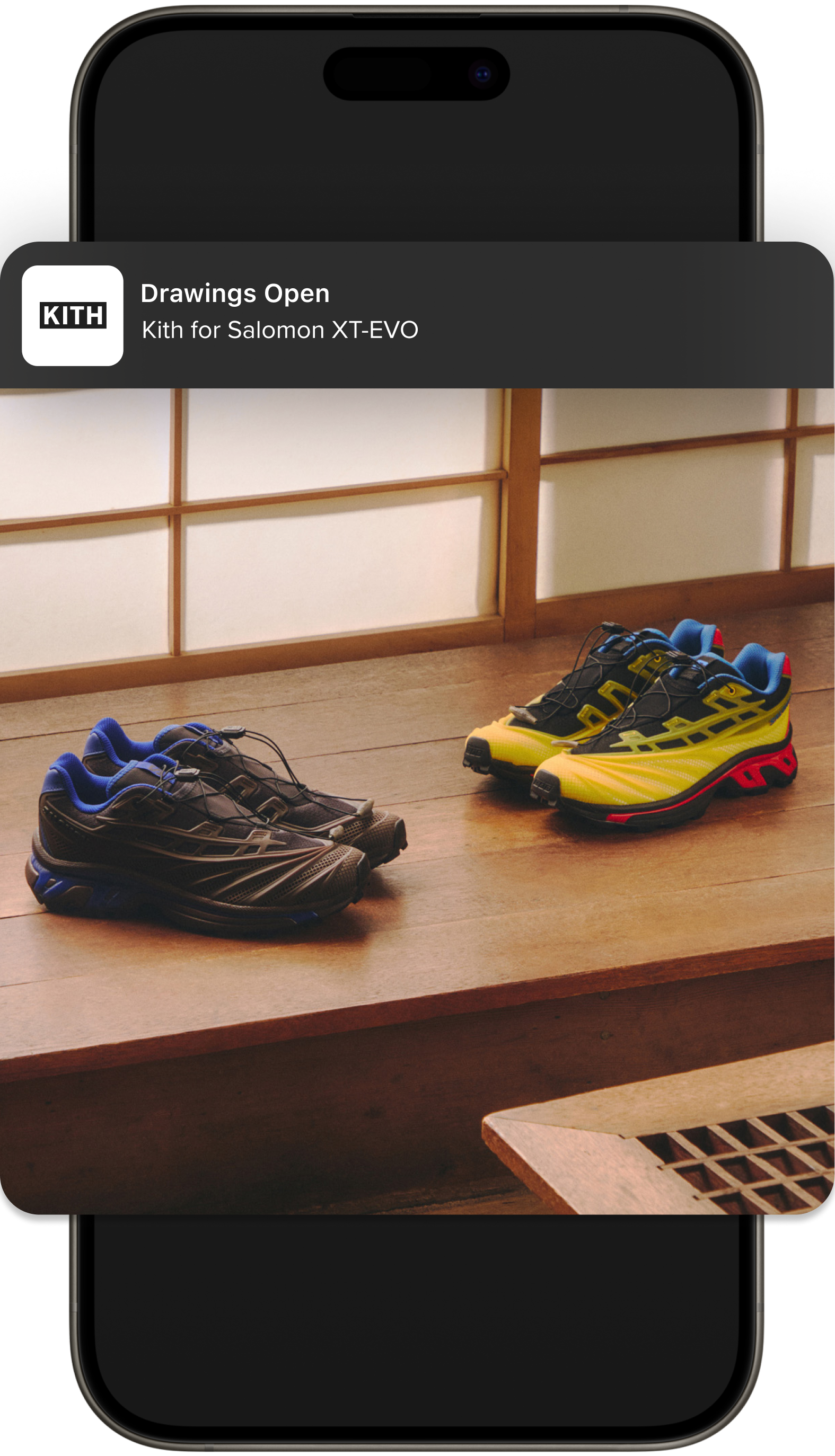 iPhone showing the Kith app Drawings Open notification for the Kith for Salomon XT-EVO, with the blue and yellow sneakers displayed on a wood shelf