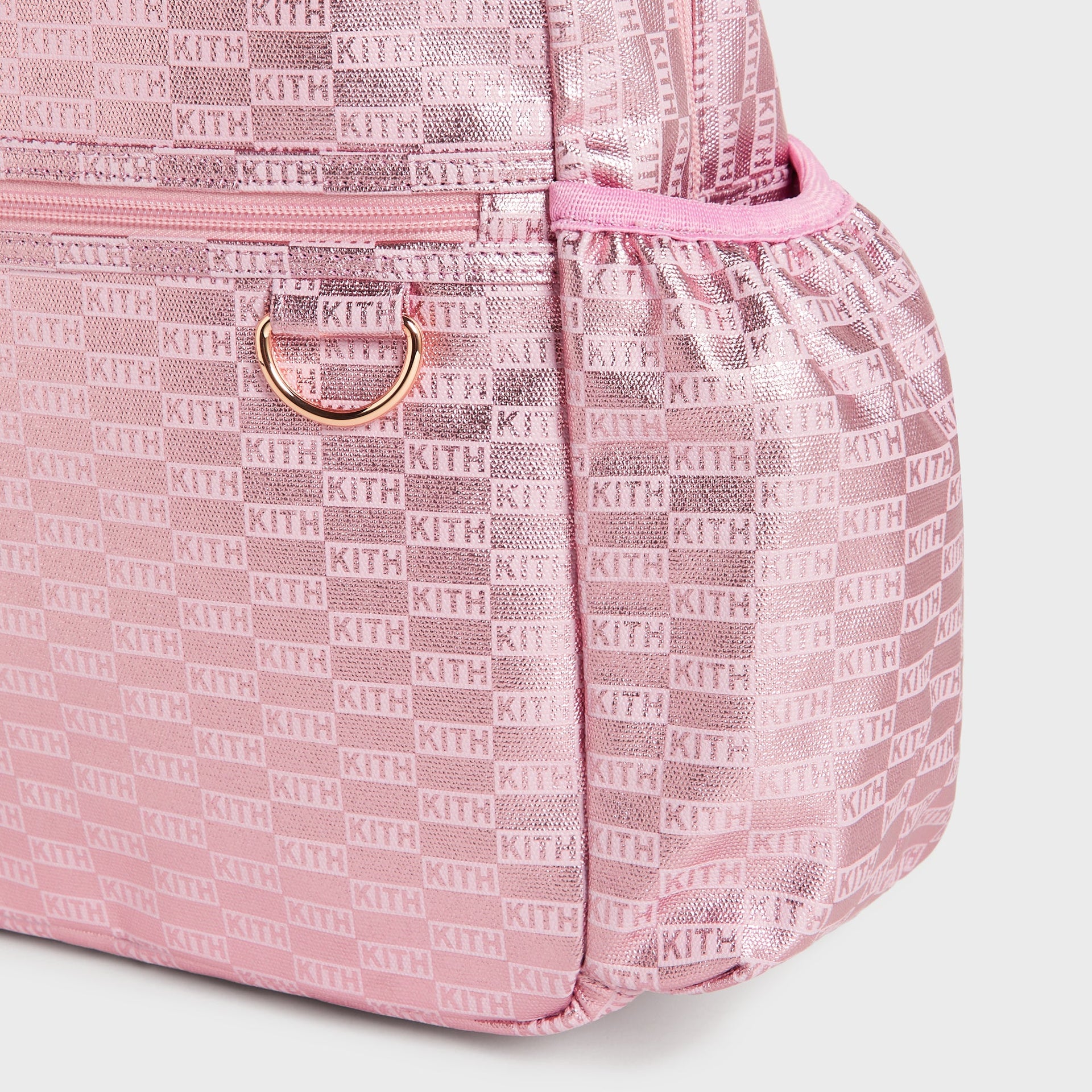Kith Kids for STATE Backpack close-up of side pocket, gold D-ring, and pink KITH monogram