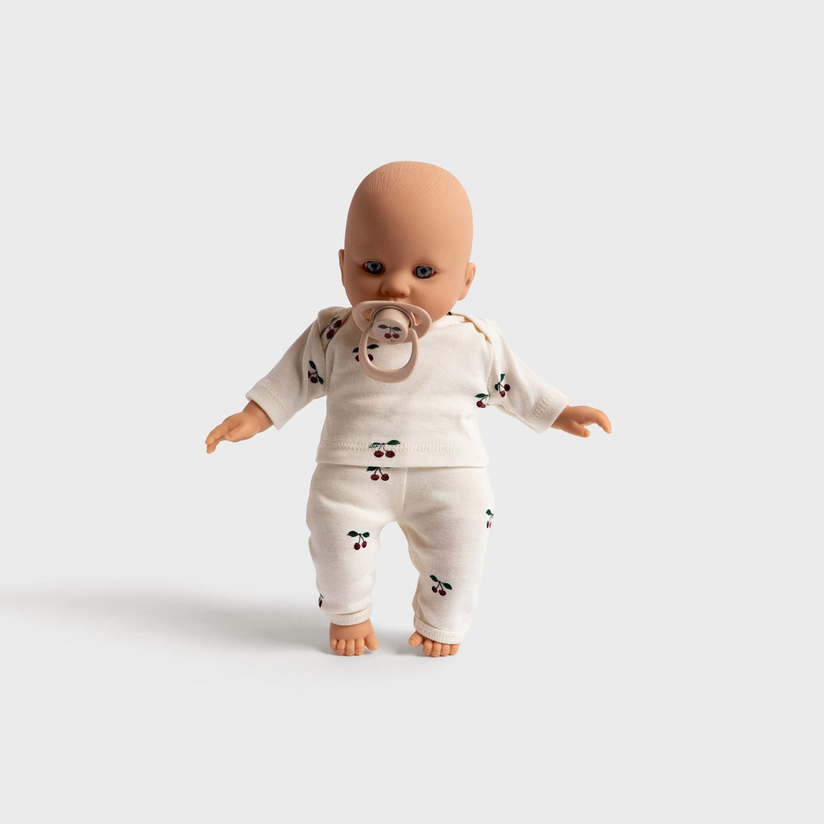 Konges Sløjd Elli the Doll in Multi, soft baby doll in a cream printed outfit, standing front view