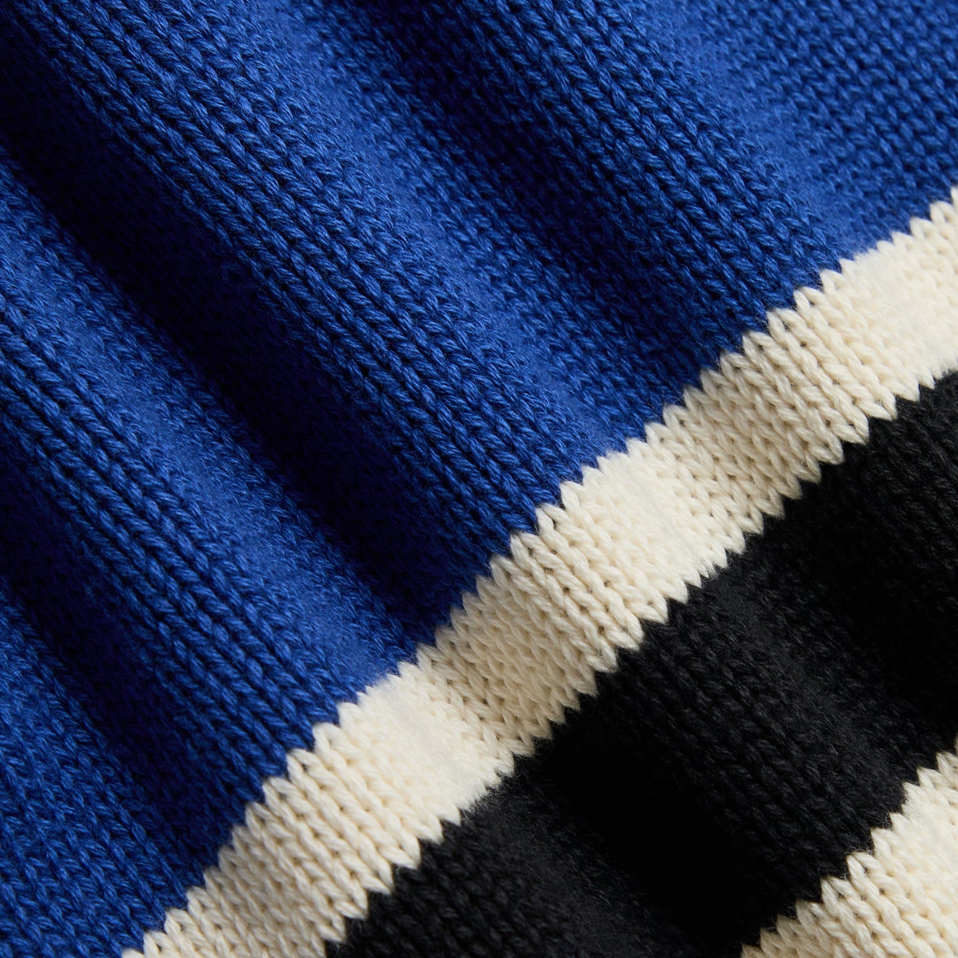 Close-up of the Kith Baby Varsity Nelson Knit Crewneck's blue, black and cream striped knit fabric