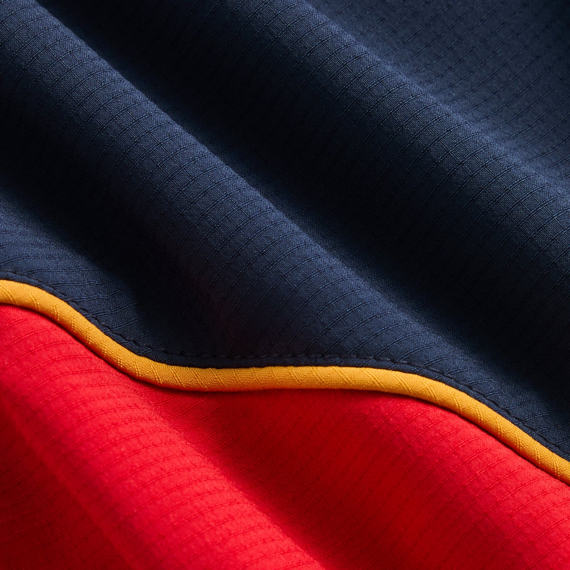 Kith Baby Mercer 8 Pant fabric close-up of navy and red panels with yellow piping detail