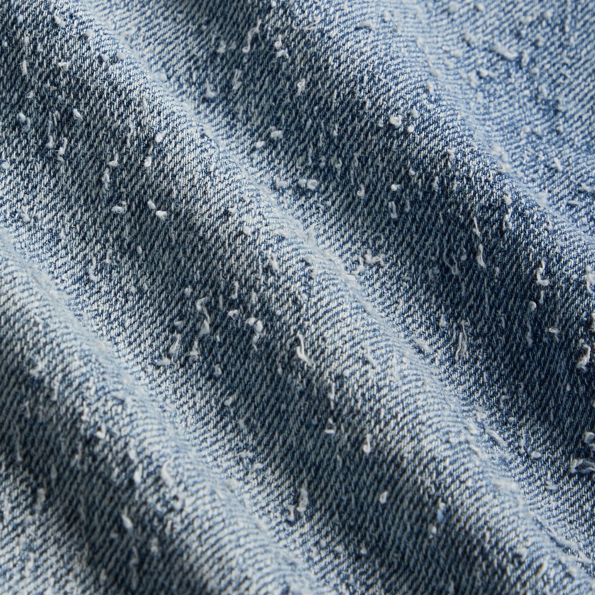 Close-up of the Kith Baby Textured Denim Chauncey Pant's acid-wash textured denim fabric