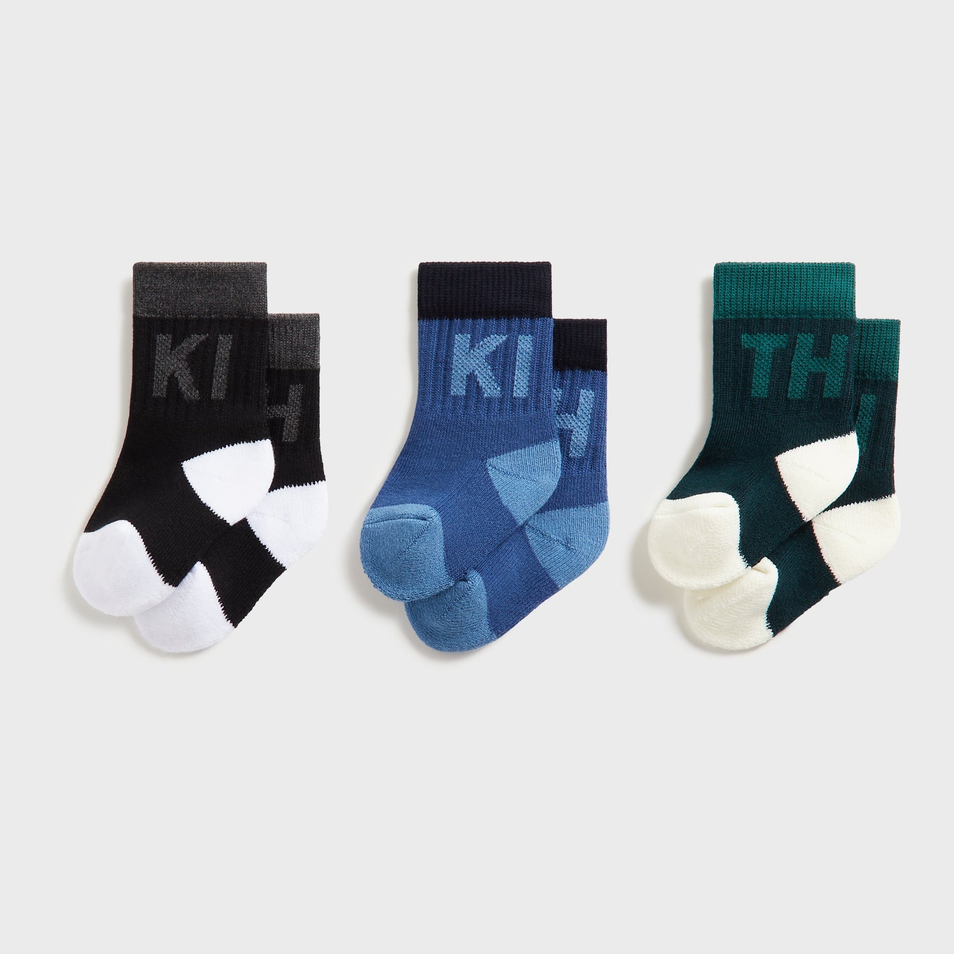 Kith Baby 3-Pack Color-Blocked Crew Socks, flat lay of black, blue and green pairs with knit KITH lettering and contrast heels