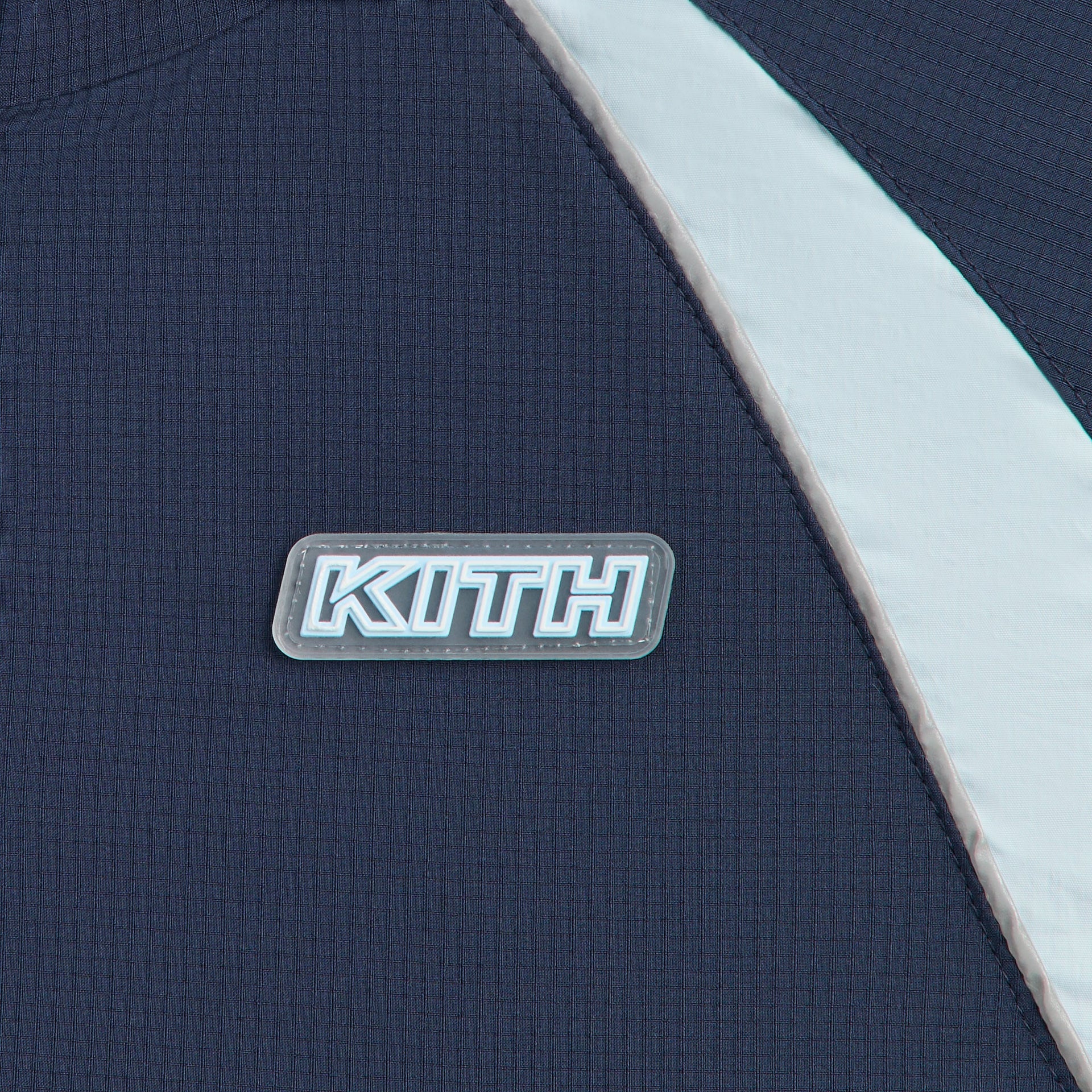 Kith Kids Lora Windbreaker Jacket close-up of navy chest with KITH rubber patch and light blue piping