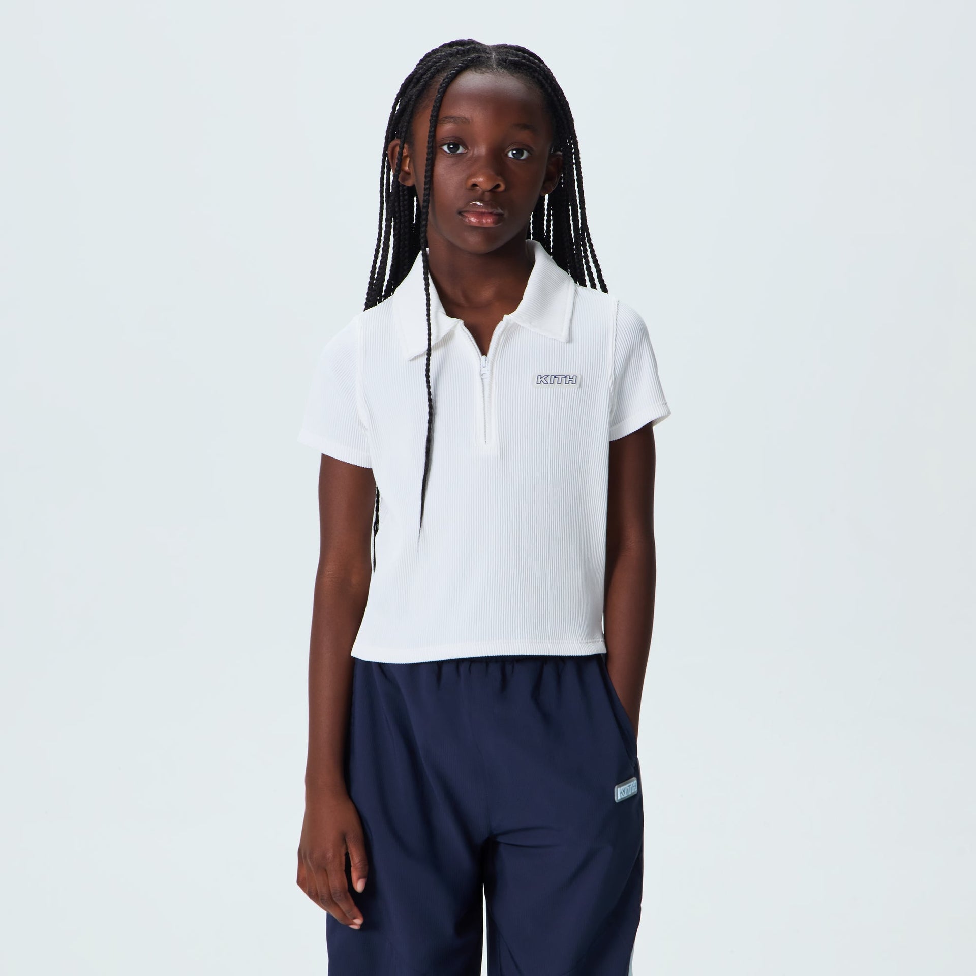 Kith Kids Active Fairway Polo in white, on-model front view worn with navy pants