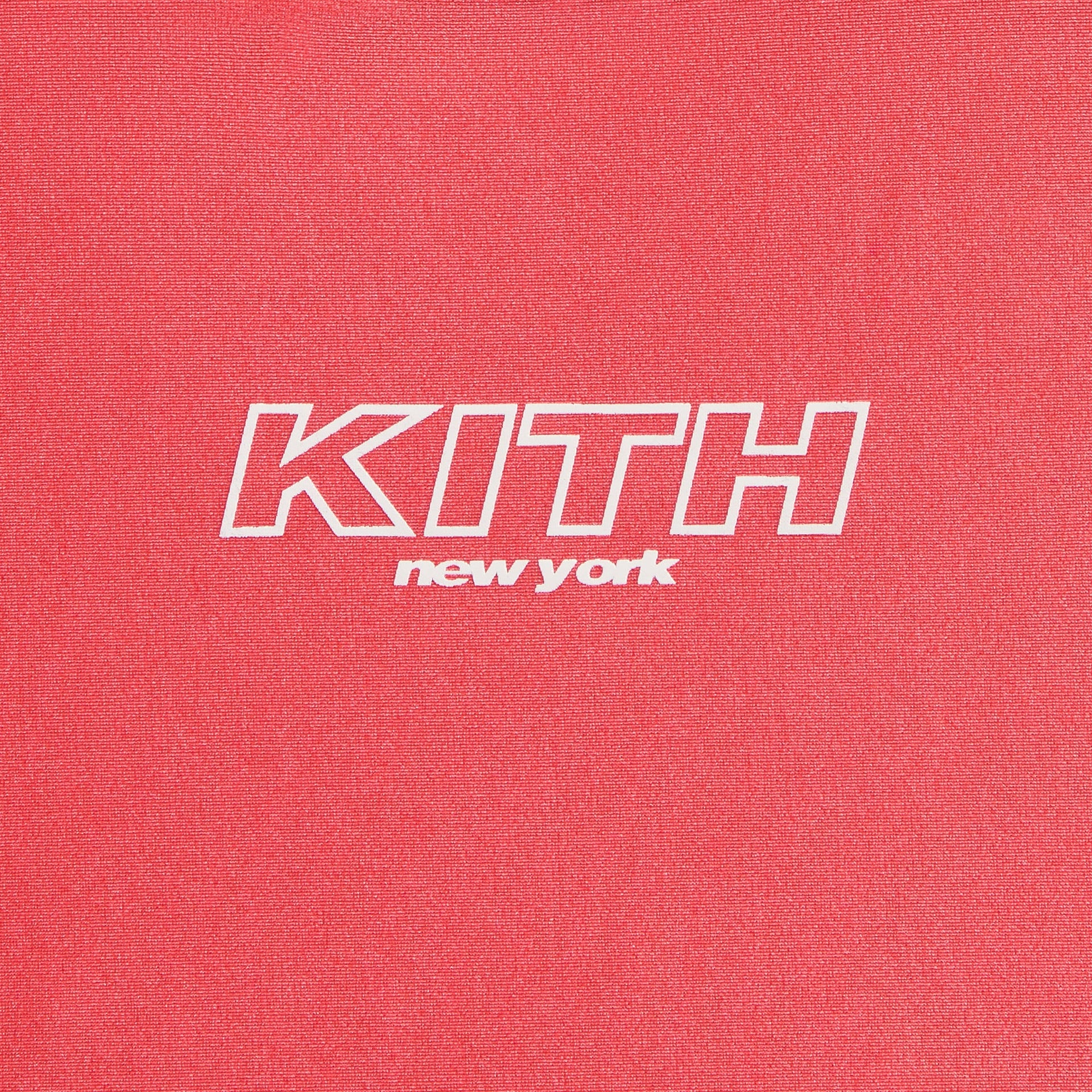 Close-up of white outline KITH New York logo on coral Carnation Kith Kids Active Fei Cropped Tee