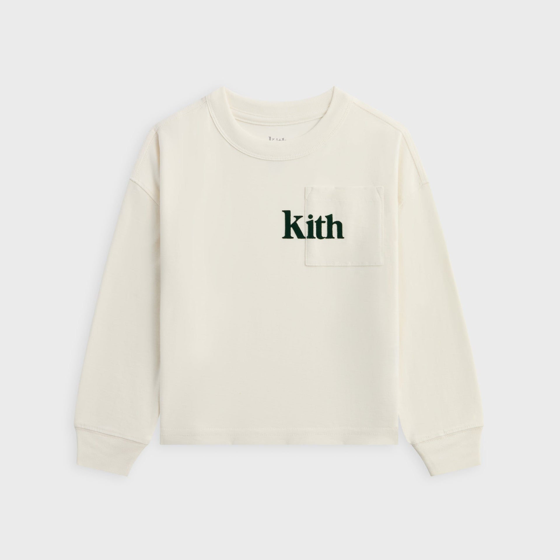 Kith Kids long sleeve Quinn tee in cream Silk, front view with chest pocket and green Kith logo