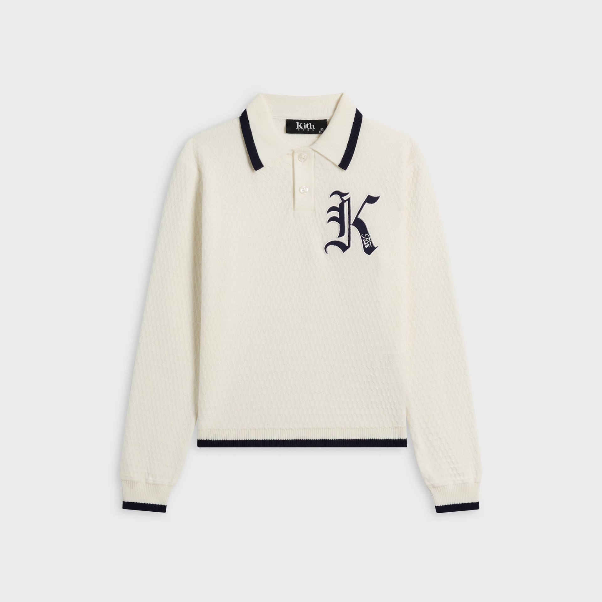 Kith Kids Tilden Long Sleeve Polo in cream knit with navy-tipped collar, front flat lay with navy K logo