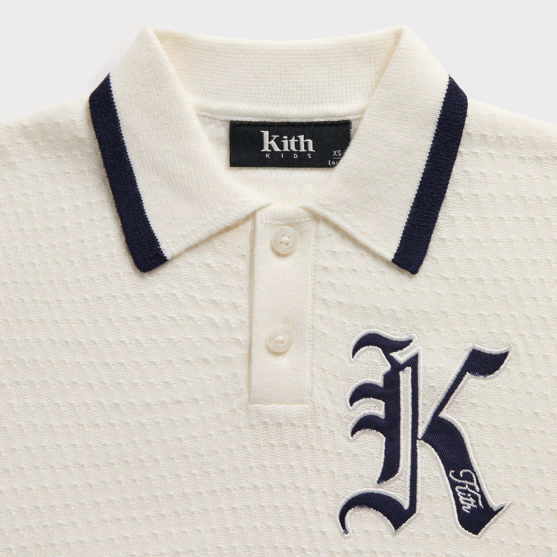 Kith Kids Tilden Polo close-up of navy-tipped collar, button placket and Old English K logo