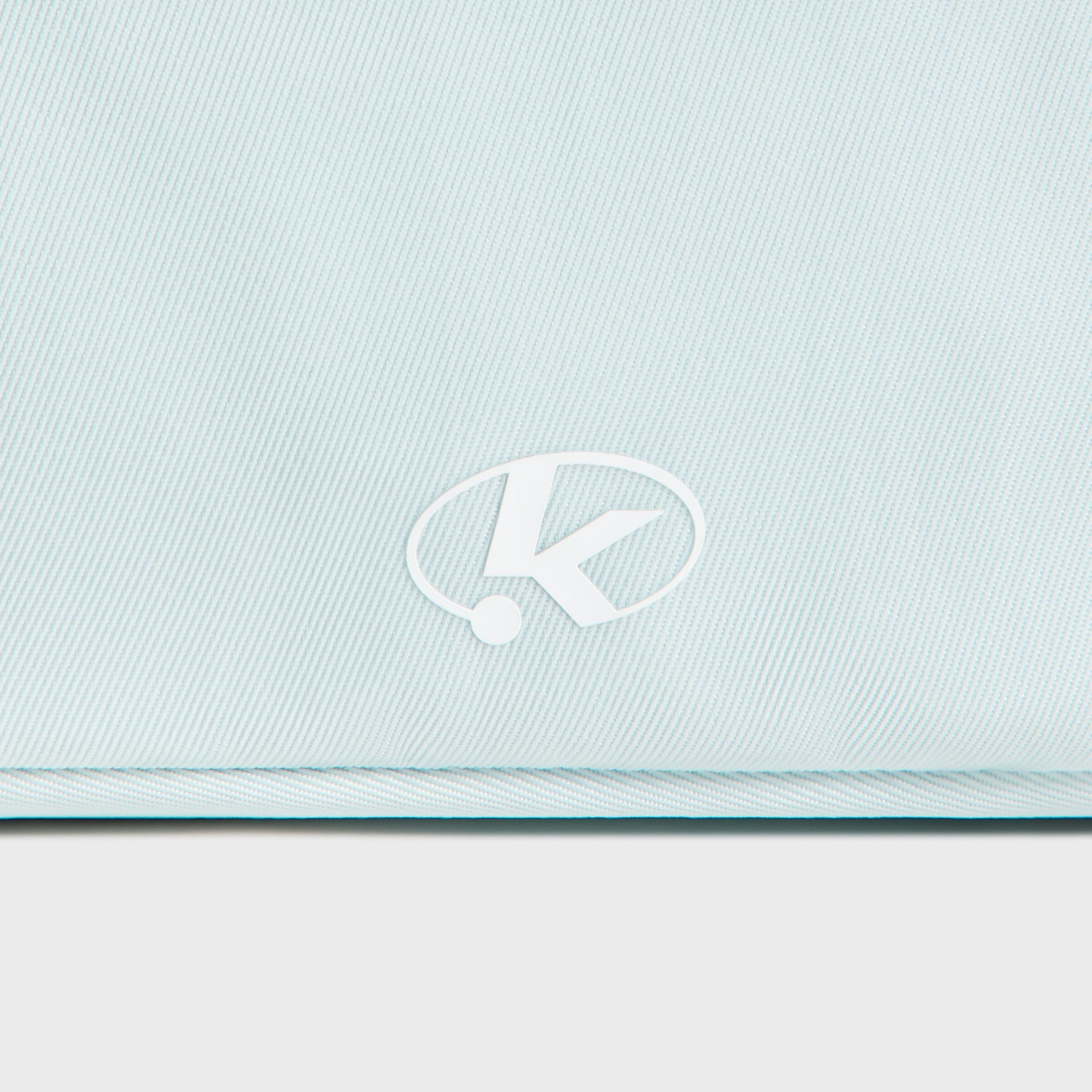 Close-up of the circular K logo on the back of the Kith Kids Active belt bag in light blue