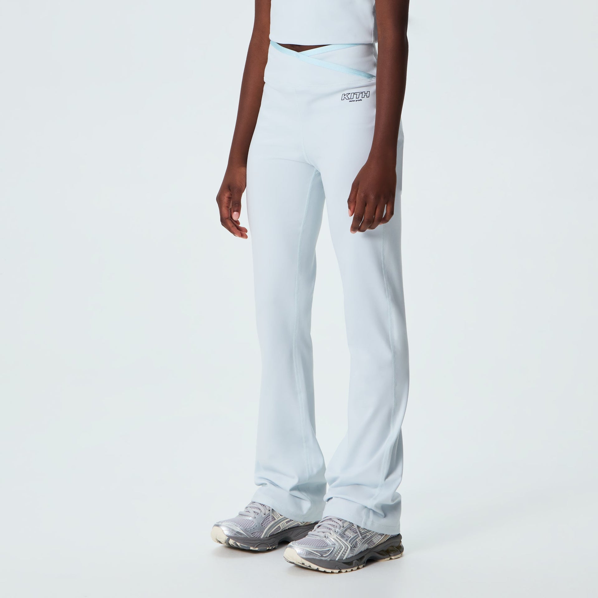Kith Kids Active Jasina Flare Legging in pale mint, on-model three-quarter view showing flared leg and sneakers