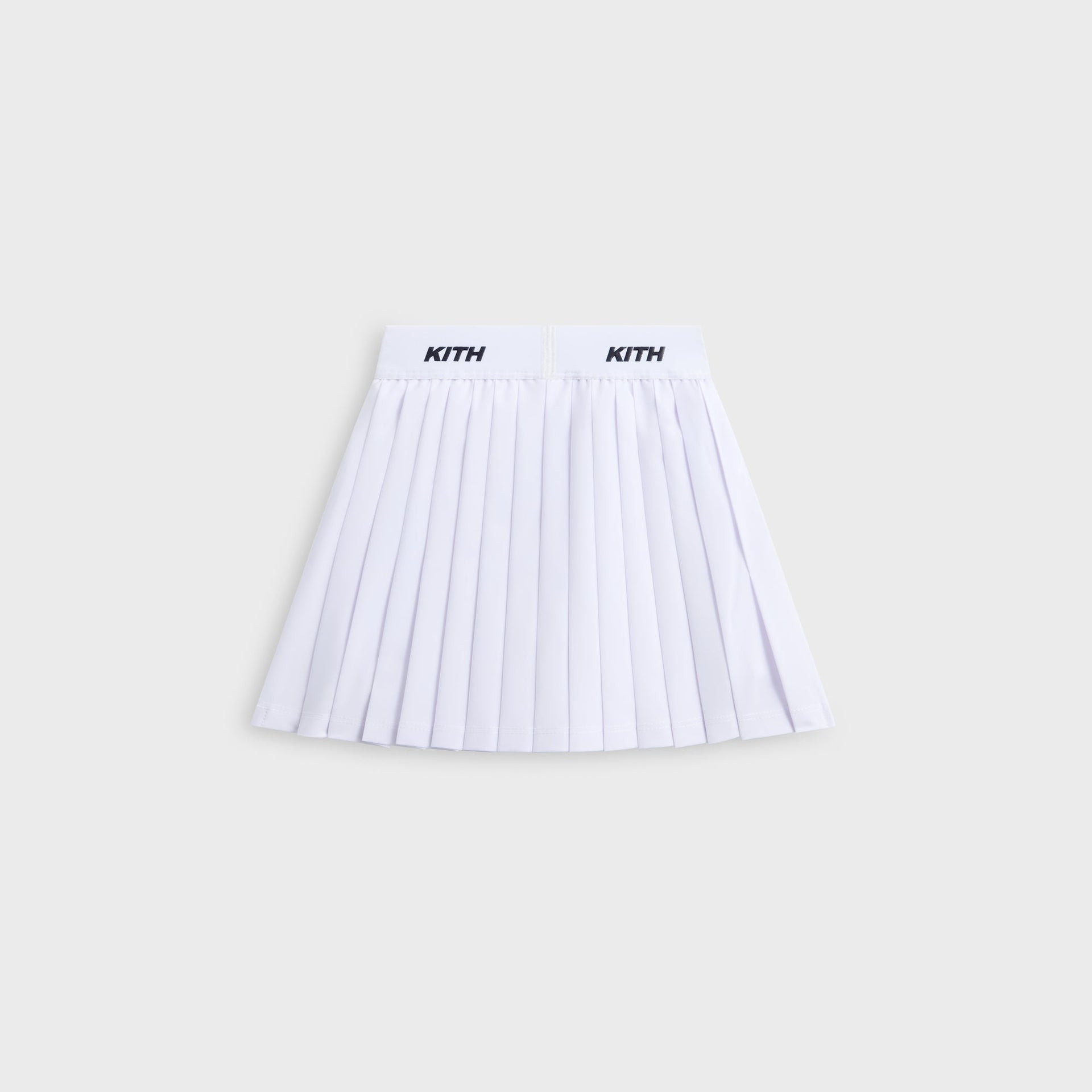 Kith Kids Amaya Tennis Mini Skort in white, flat lay back view with pleats and KITH waistband