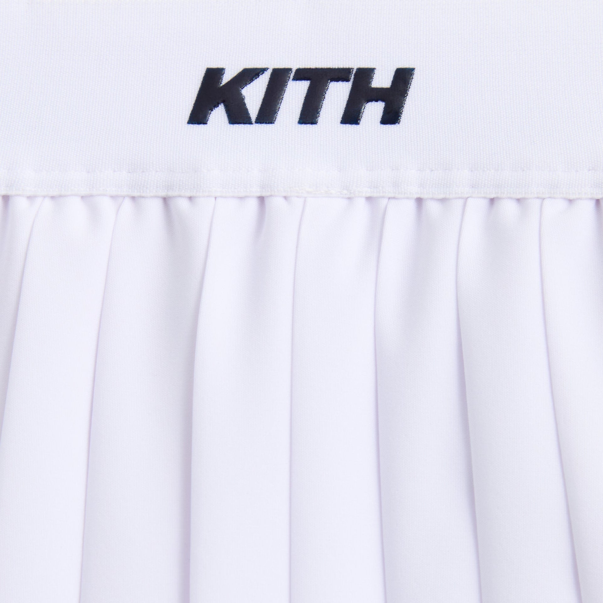 Kith Kids Amaya Tennis Mini Skort in white, close-up of navy KITH logo on elastic waistband