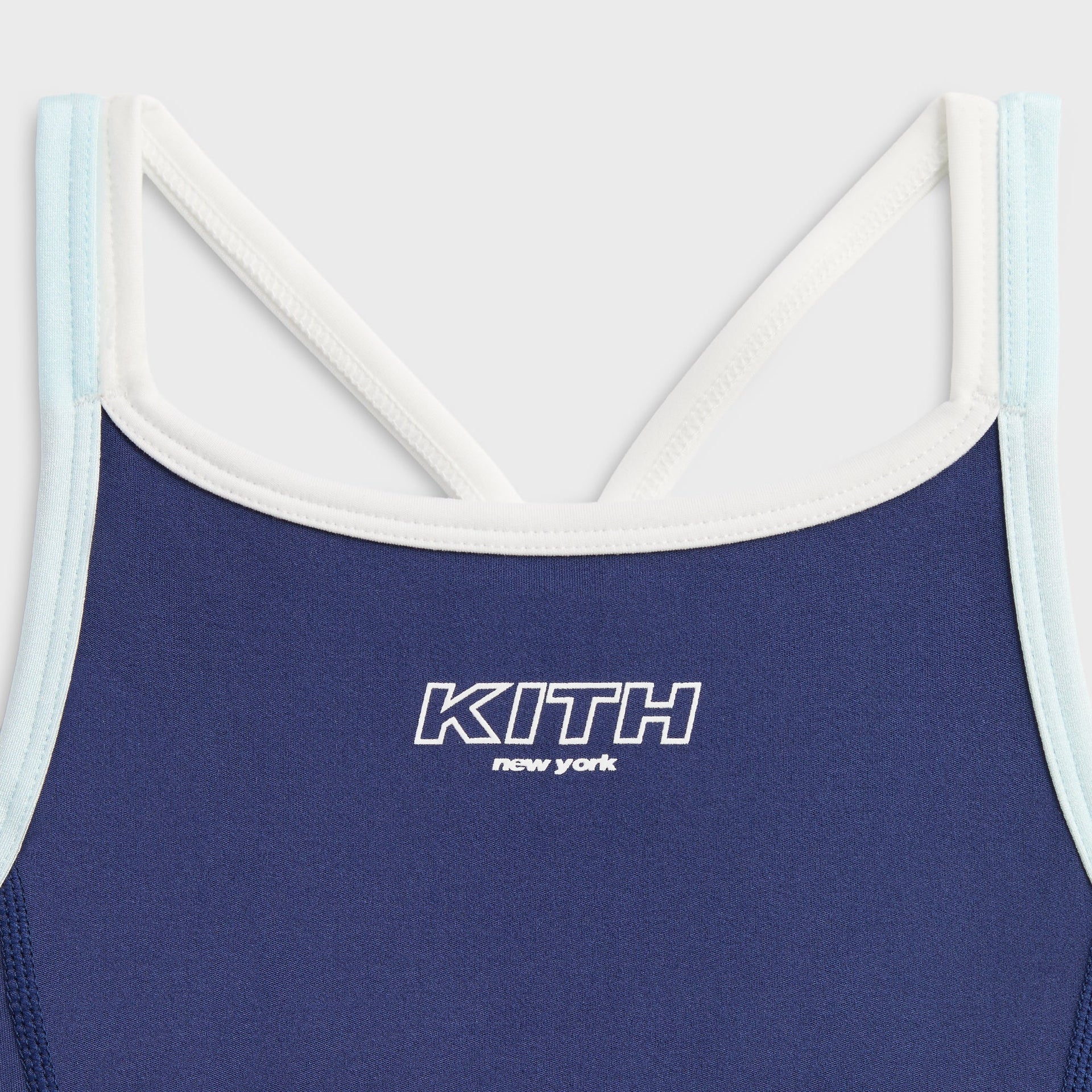 Kith Kids Active Skye Romper Dress in Nocturnal navy, close-up of crossed back straps and outlined KITH New York logo