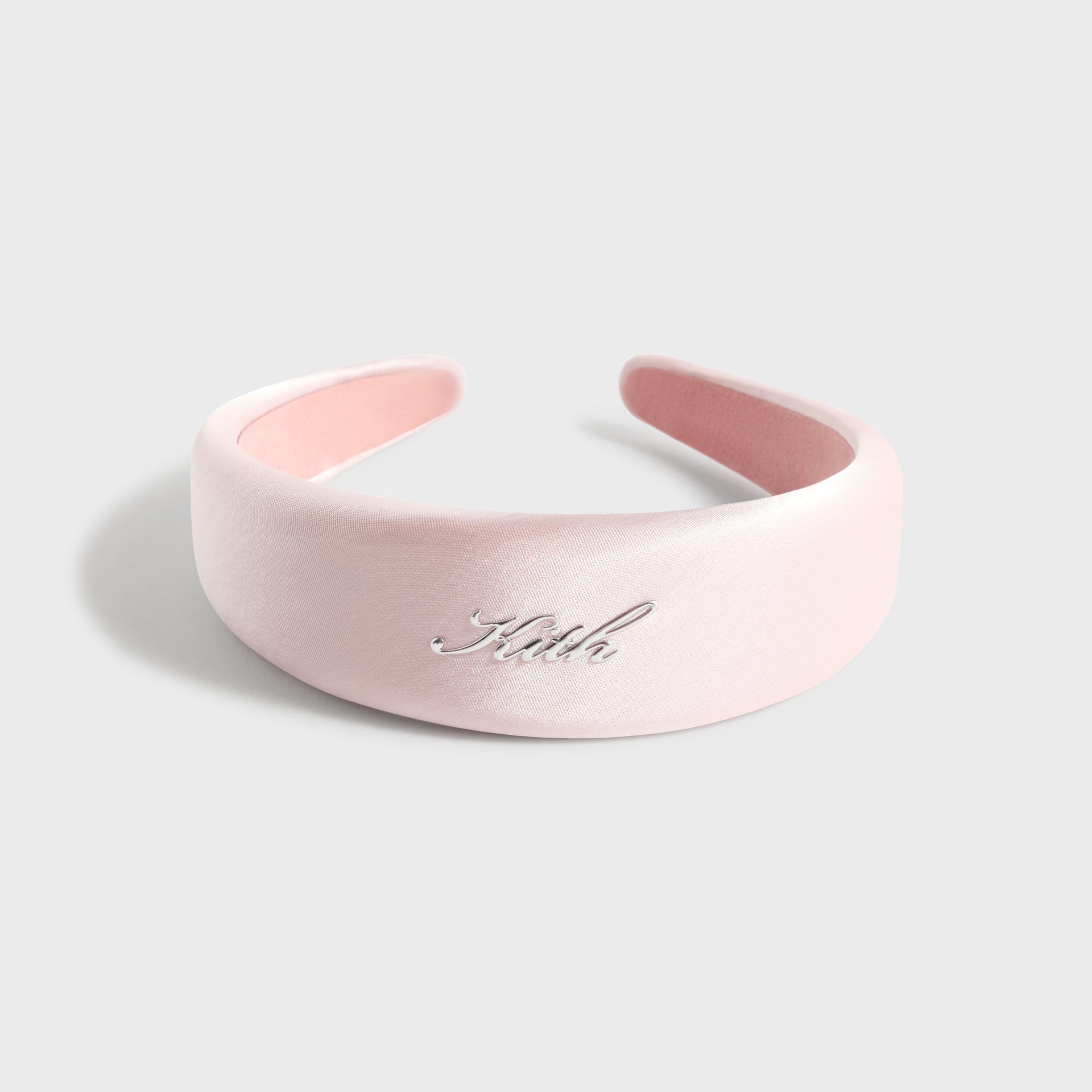 Kith Kids Satin Headband in Bloom pink, top view showing silver Kith script and pink underside