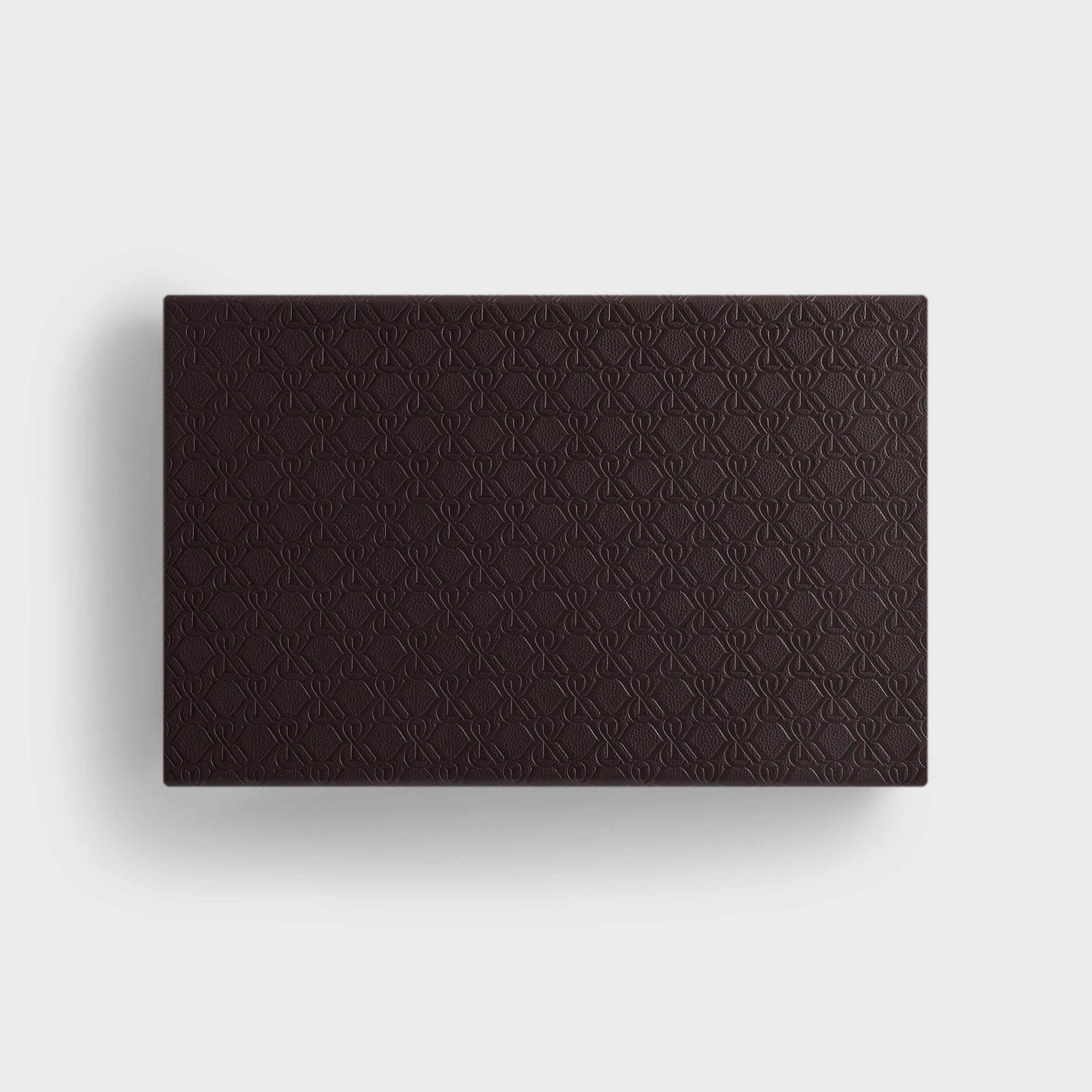 Kith Crest Monogram Backgammon Board closed, showing dark brown leather exterior with embossed monogram pattern