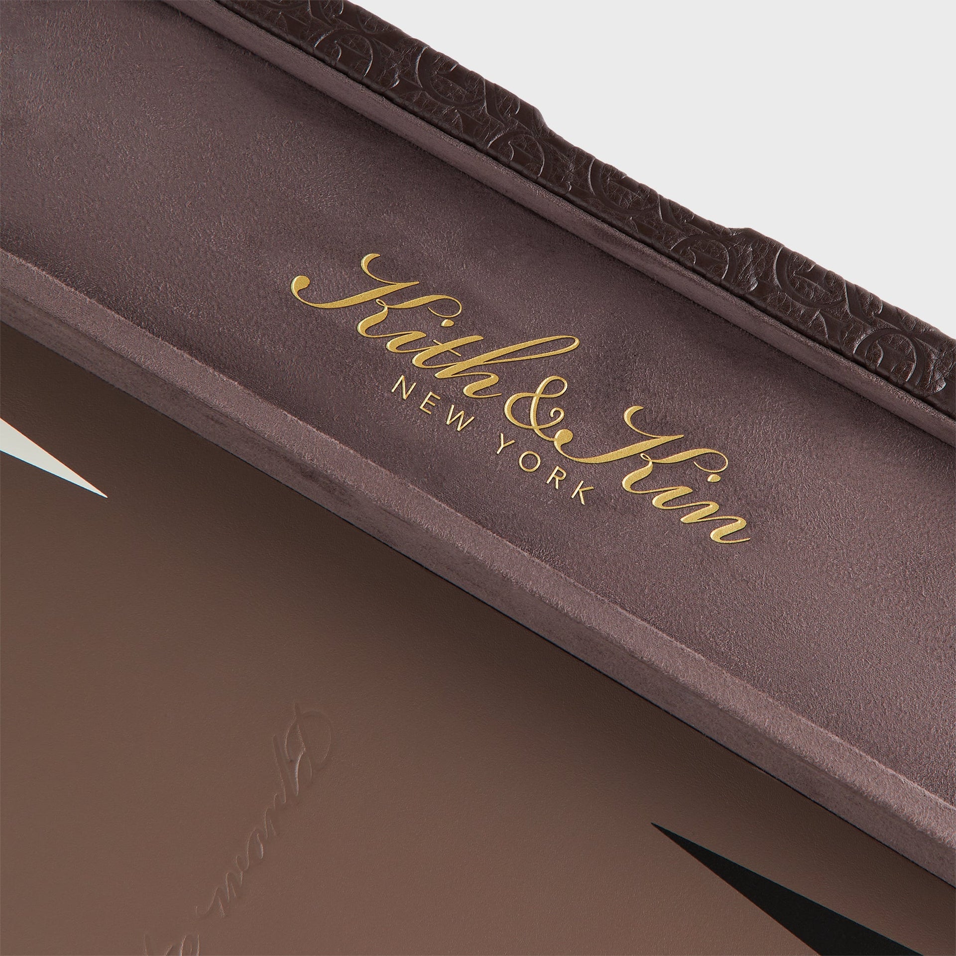 Detail of the gold foil Kith & Kin New York logo stamped inside the backgammon case lid