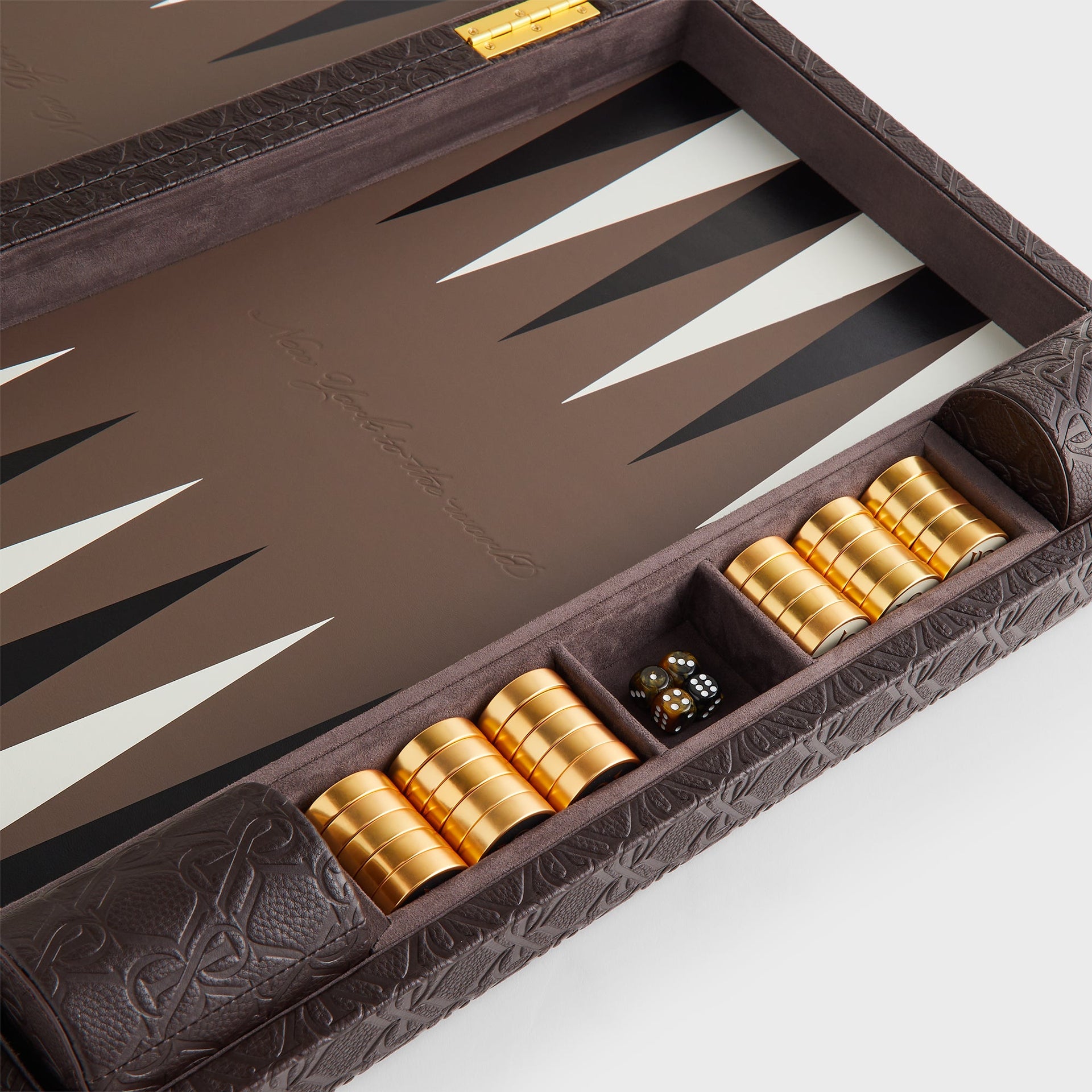 Close-up of the leather-lined checker and dice tray with gold hinges on the Kith Crest Monogram Backgammon Board