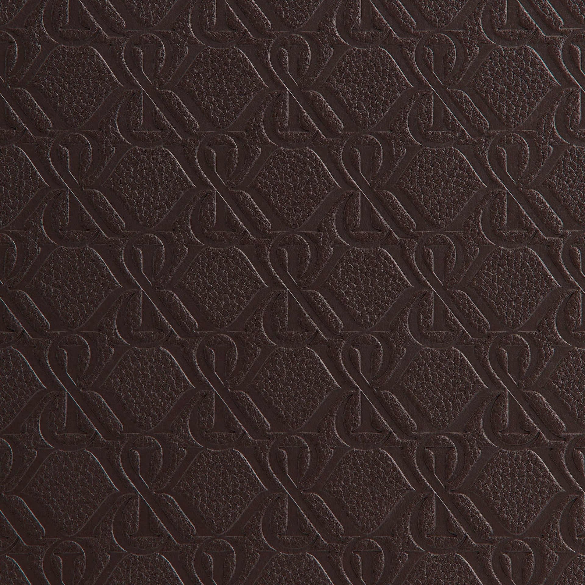 Extreme close-up of the embossed leather monogram texture on the Kith Crest Monogram Backgammon case