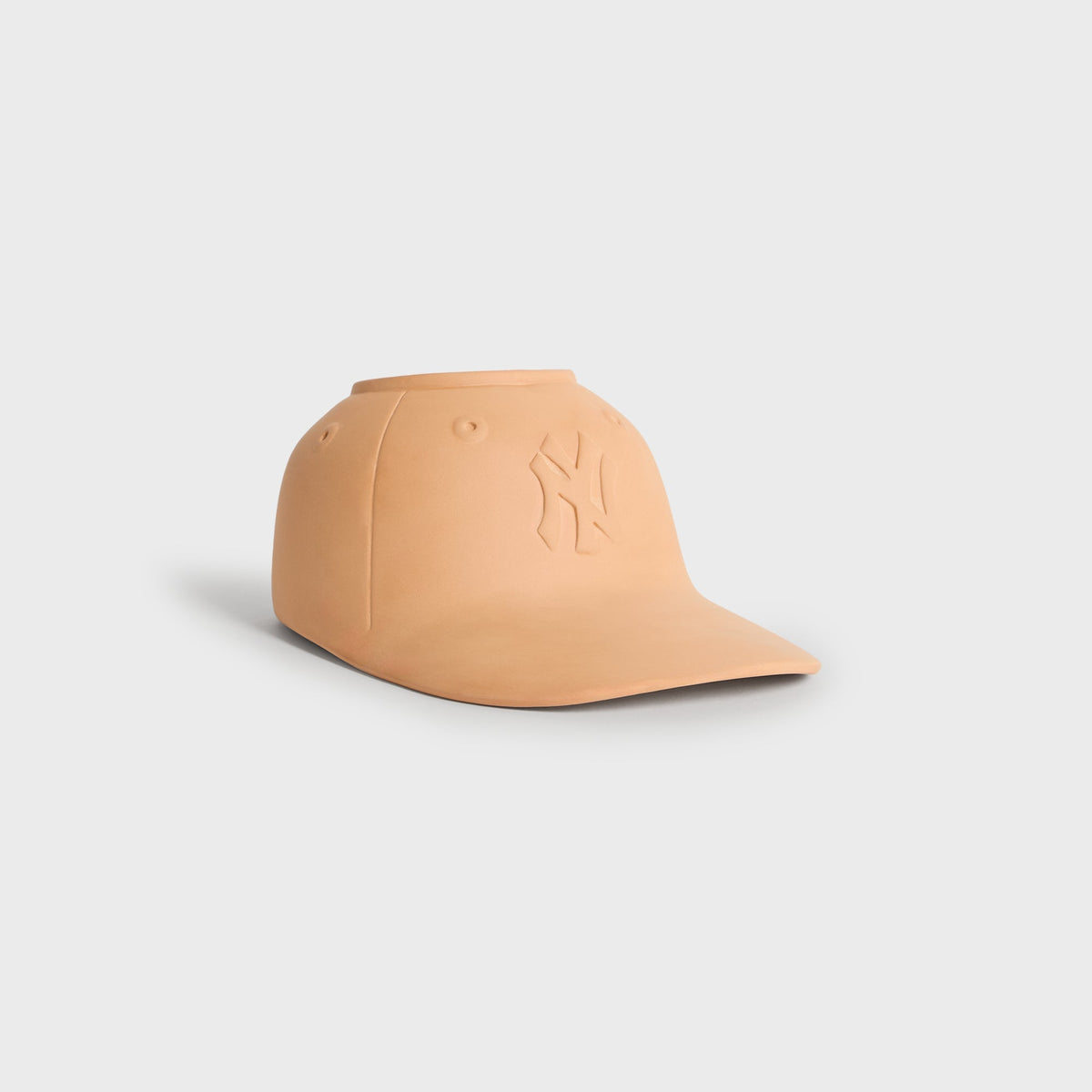 Side angle of the terracotta baseball cap planter showing the brim and NY logo in profile