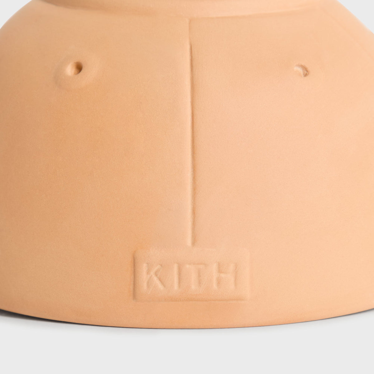 Close-up detail of the embossed Kith wordmark and drainage holes on the planter's back