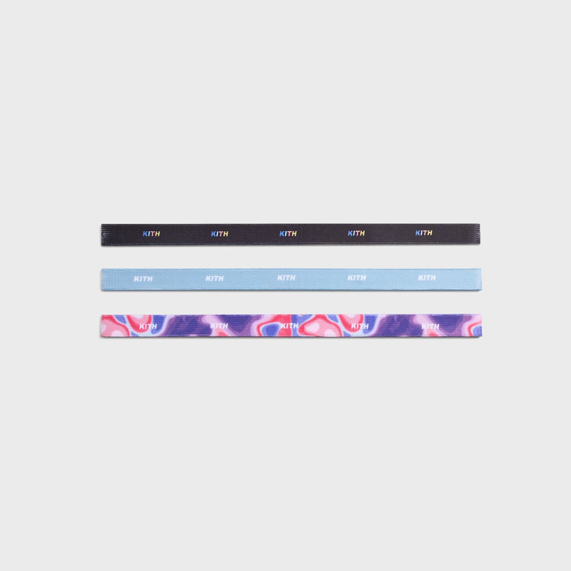 Kith Kids 3-Pack Printed Headbands flat lay, black rainbow logo, light blue, and pink-purple swirl designs