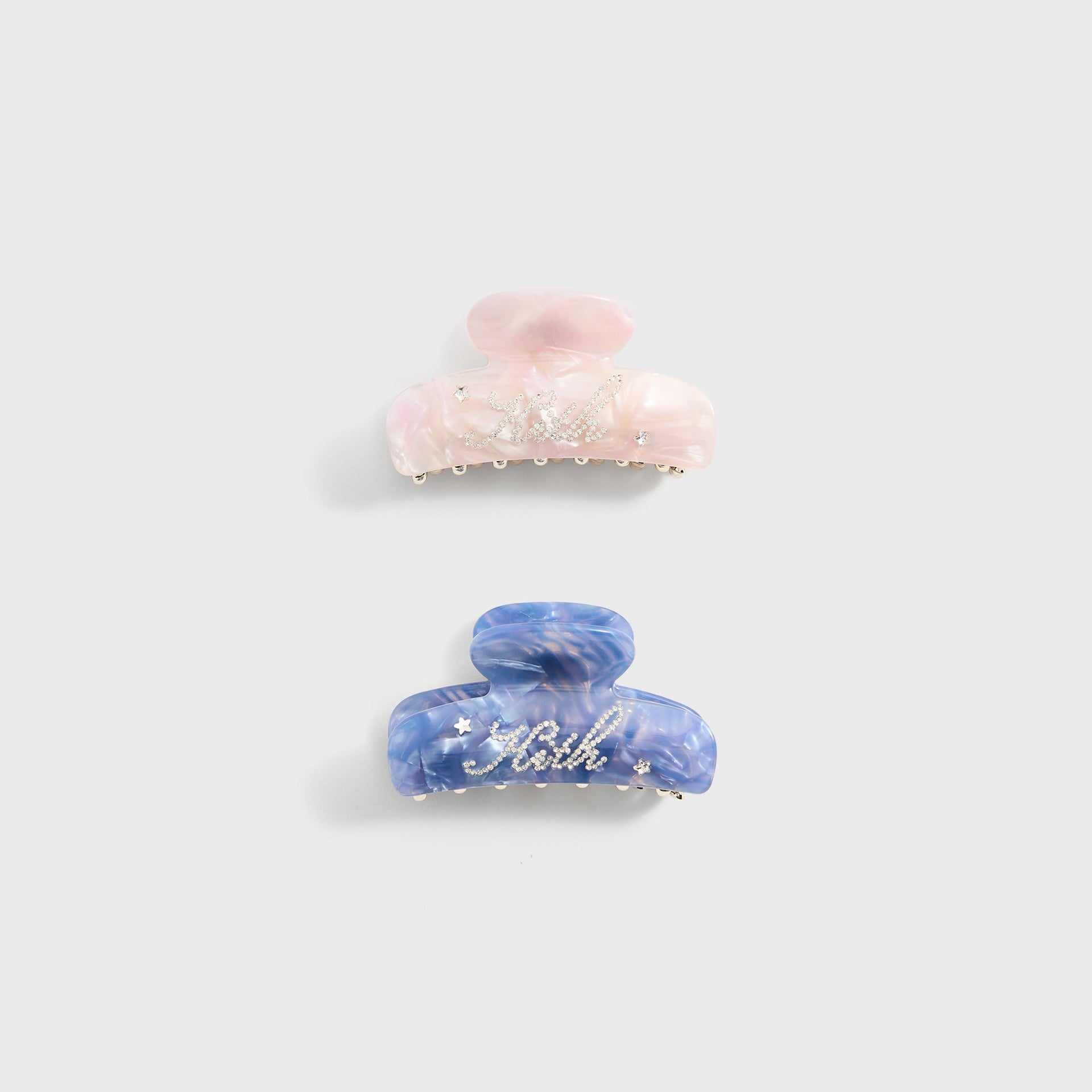 Kith Kids Set of 2 Rhinestone Hair Clips flat lay, pink and blue marbled claw clips with Kith script
