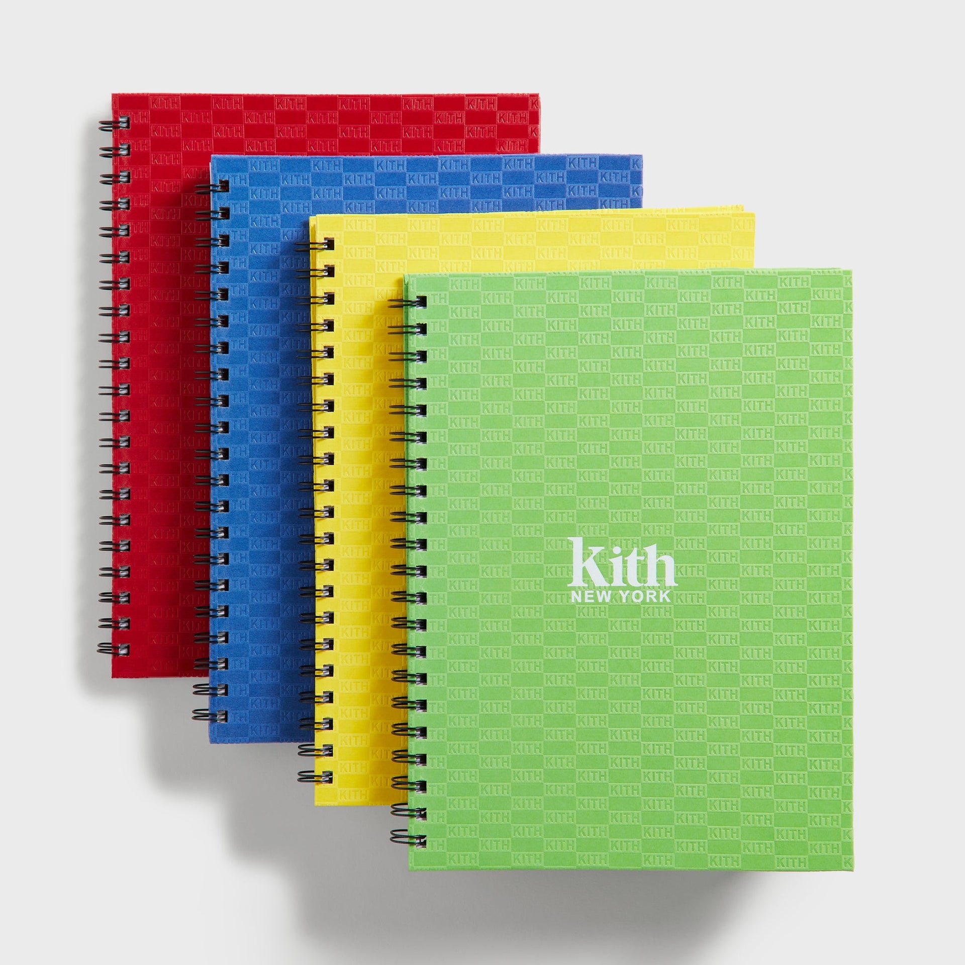 Kith Kids Back to School Set, four spiral-bound Kith monogram notebooks in red, blue, yellow and green