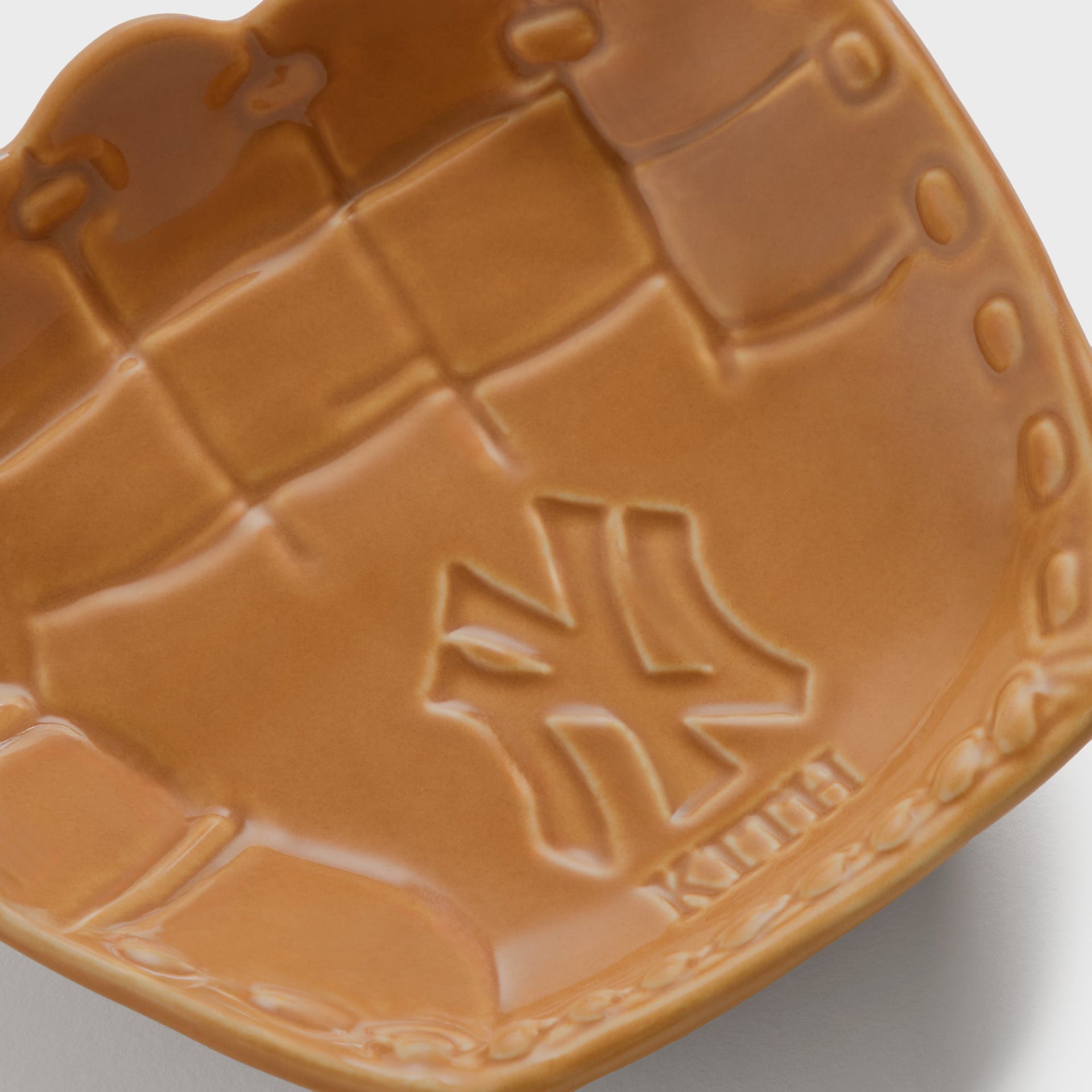 Kith x Yankees Baseball Glove Catchall Tray in tan - close-up detail of embossed NY logo and Kith wordmark