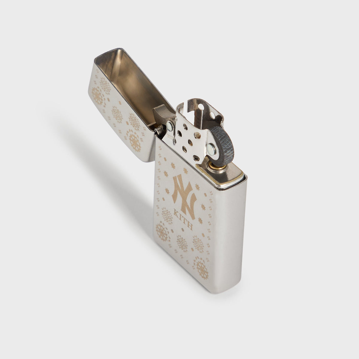 Kith x New York Yankees silver Zippo lighter open at an angle, showing hinge and flint wheel