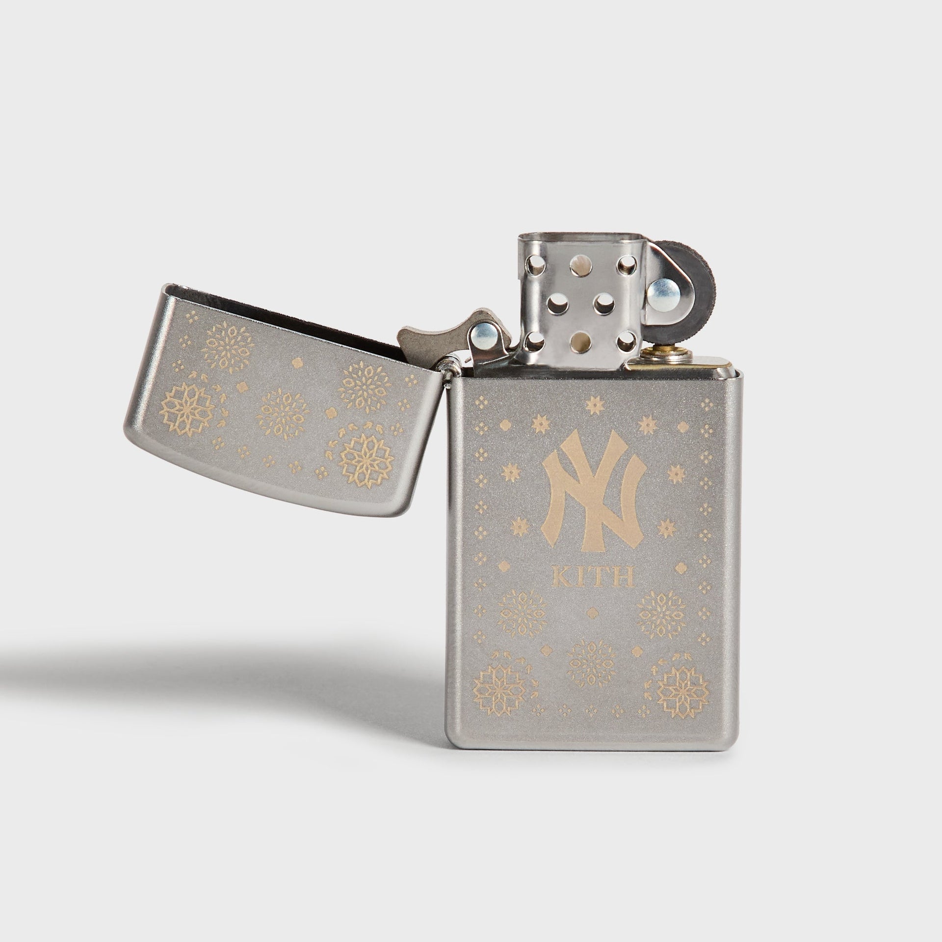 Kith x New York Yankees silver Zippo lighter open, showing flint wheel and NY logo front