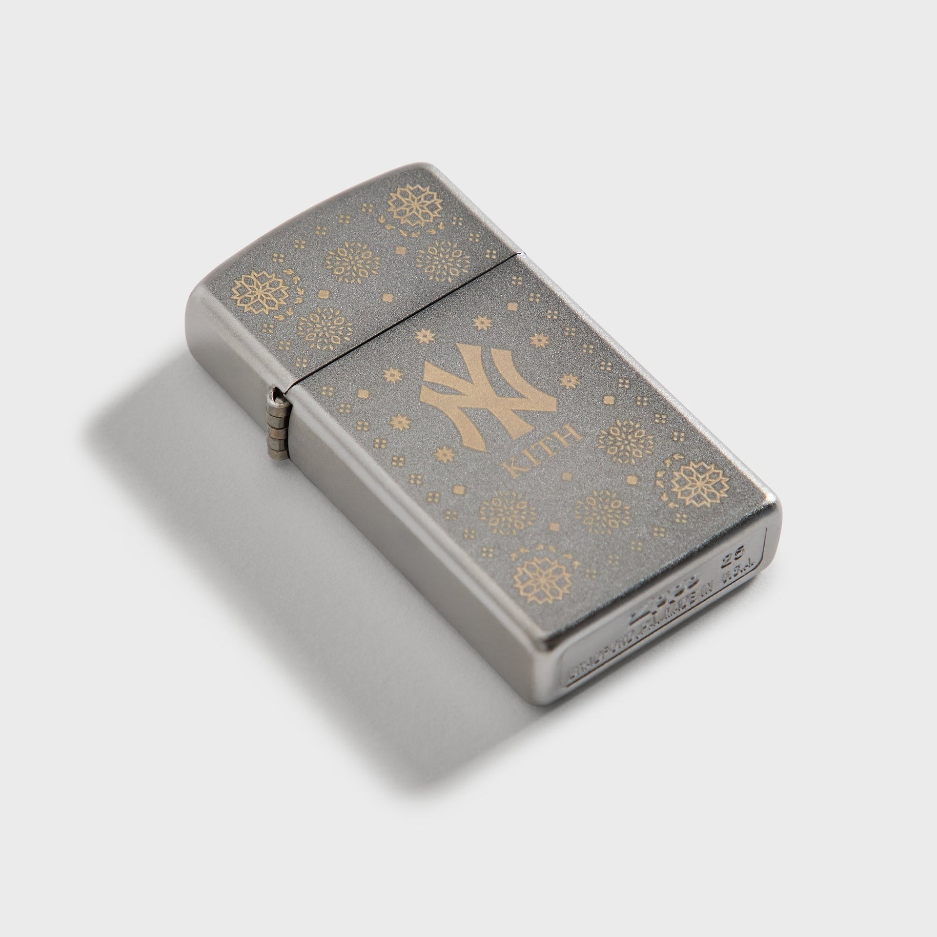 Kith x New York Yankees silver Zippo lighter closed, angled top-down view of engraving