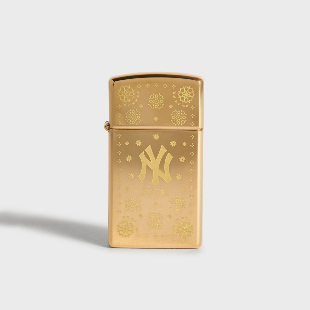 Kith x New York Yankees gold Zippo lighter, closed front with bandana pattern and NY logo