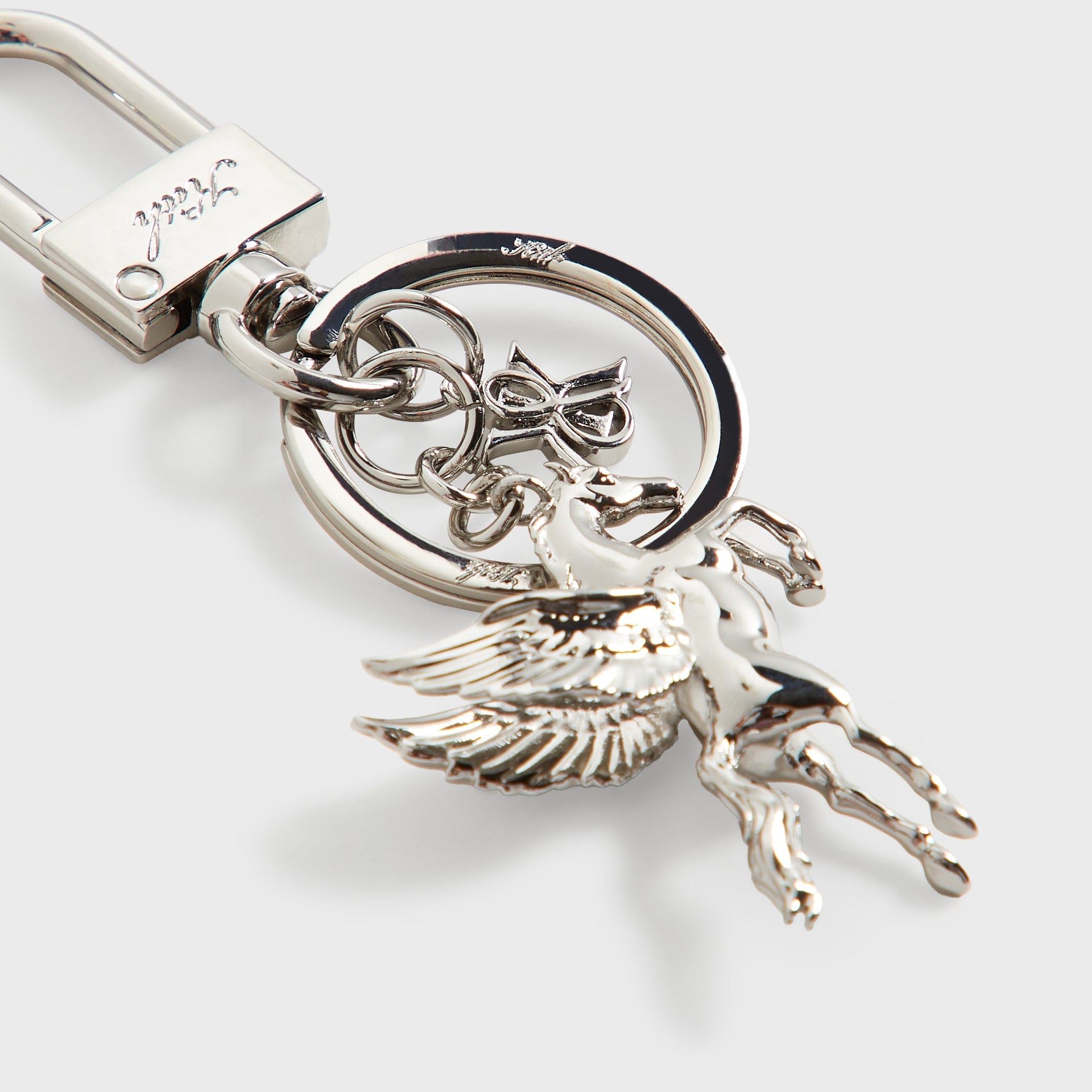 Close-up detail of the Kith Pegasus Keyring in silver, showing the engraved Kith logo tag and lobster clasp closure