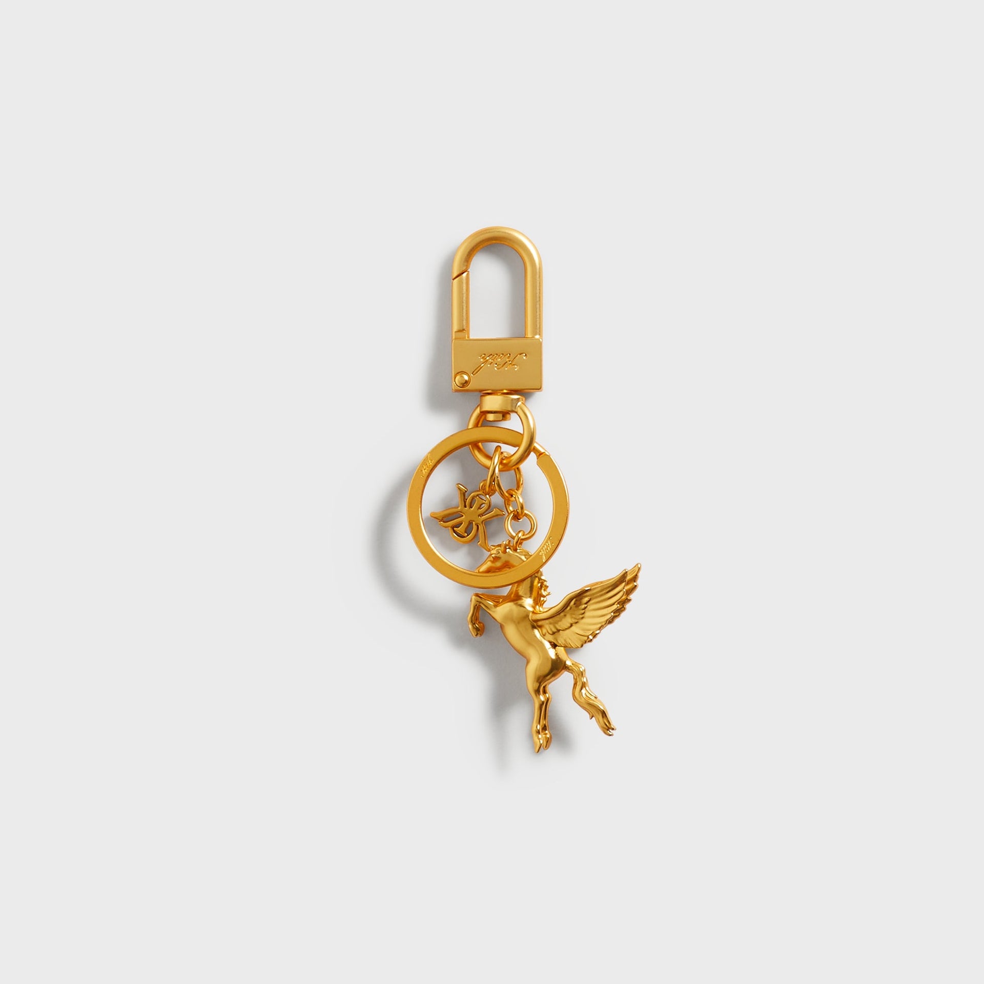 Kith Pegasus Keyring in Gold, straight-on view showing the gold-tone Pegasus and X&K charms