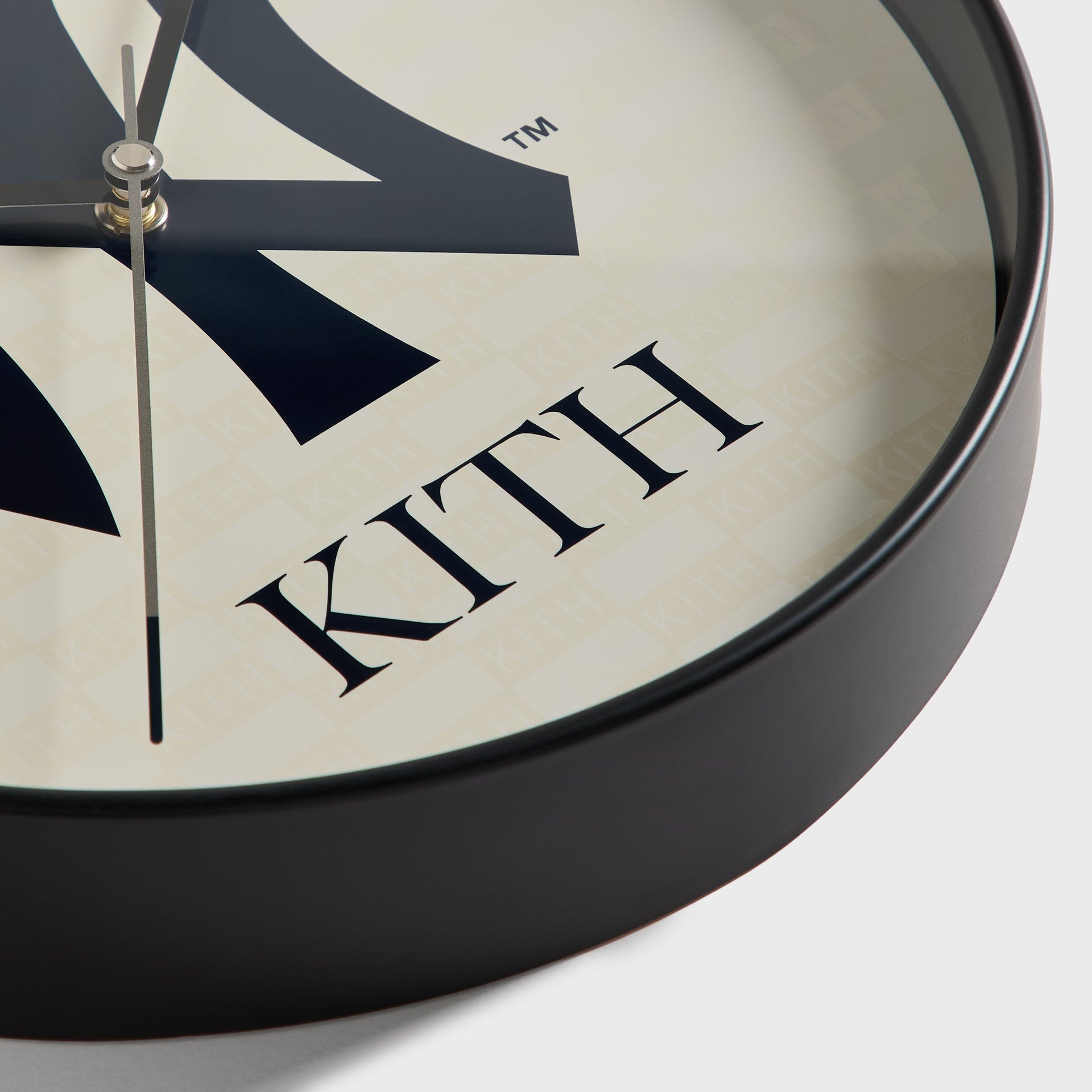 Close-up detail of clock rim and Kith-pattern dial background on the wall clock