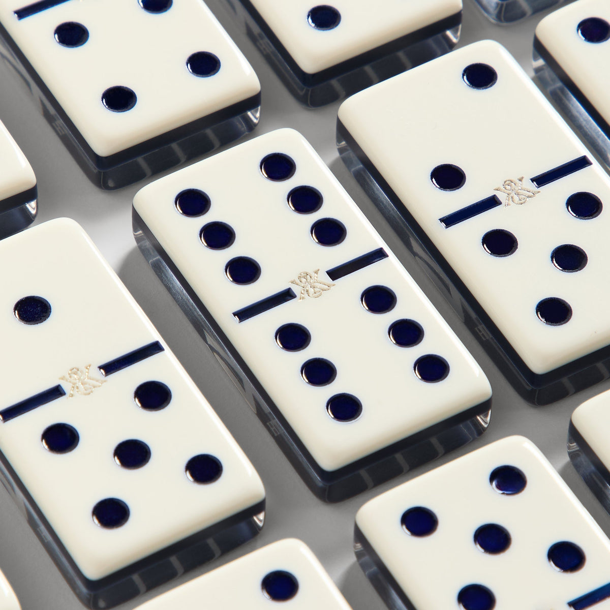 Diagonal close-up of domino tile faces showing pip counts and the Kith ampersand emblem