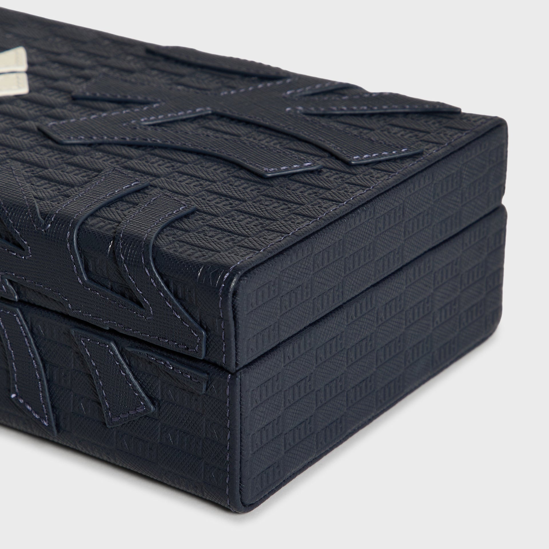 Closed Kith x New York Yankees domino case, front view with brass latch and NY logo patch