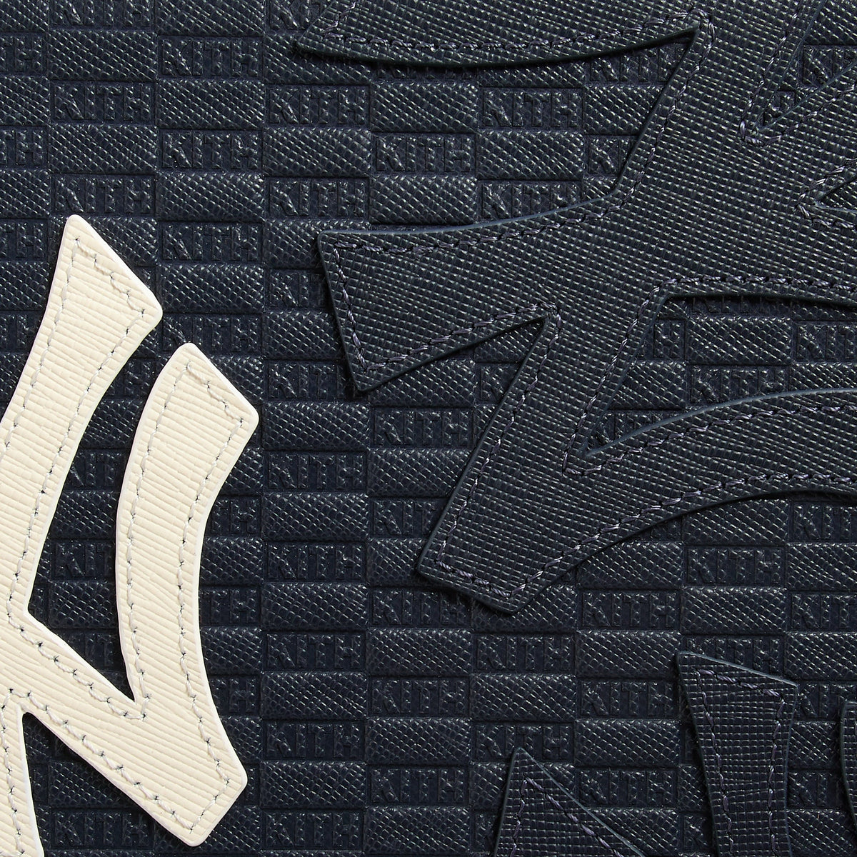 Close-up of the domino case's corner hinge and stitched leather pattern
