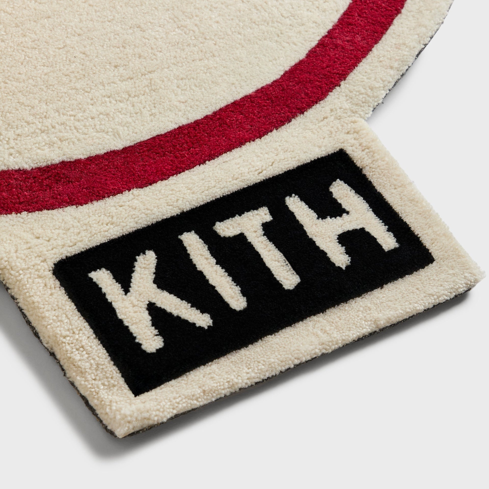 Close-up of the Kith label and red border stitching on the Yankees logo tufted rug