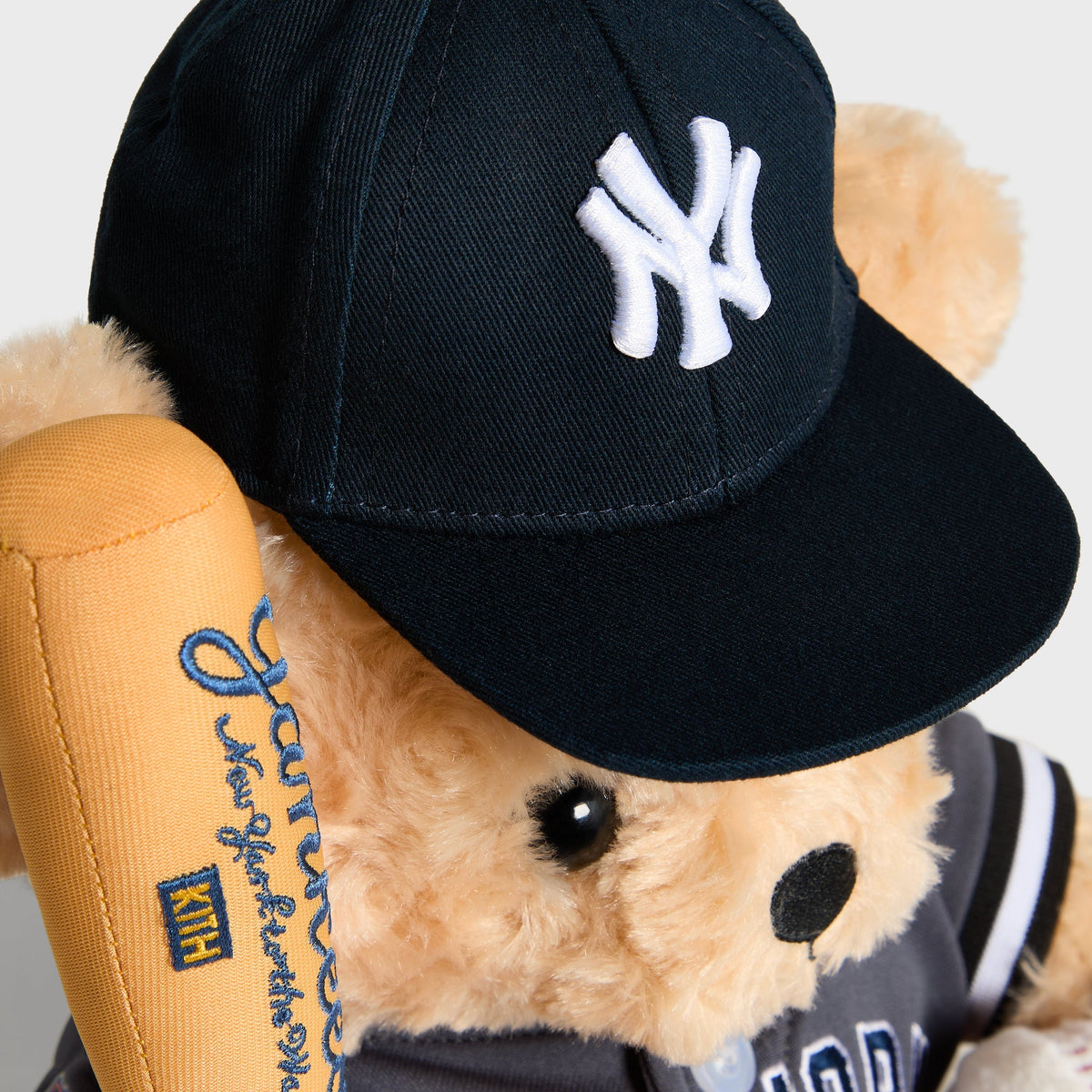 Close-up of NY logo embroidered on the navy cap worn by the Skyscraper Teddy Bear