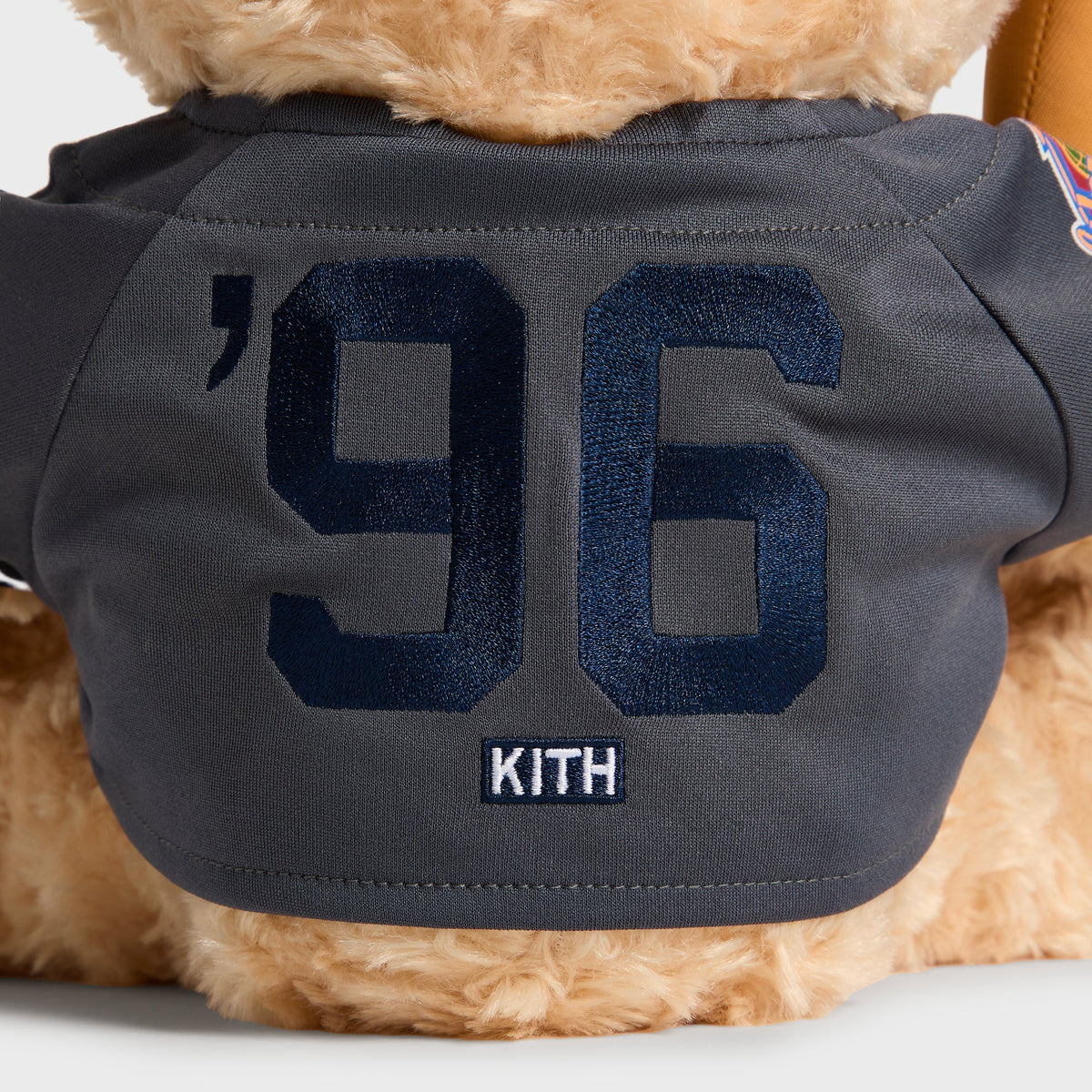 Close-up of embroidered '96 Kith lettering on the jersey back of the Skyscraper Teddy Bear