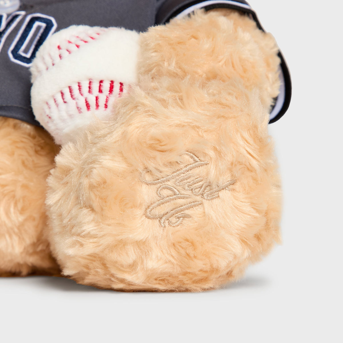 Close-up of Kith signature embroidered on the paw of the Skyscraper Teddy Bear