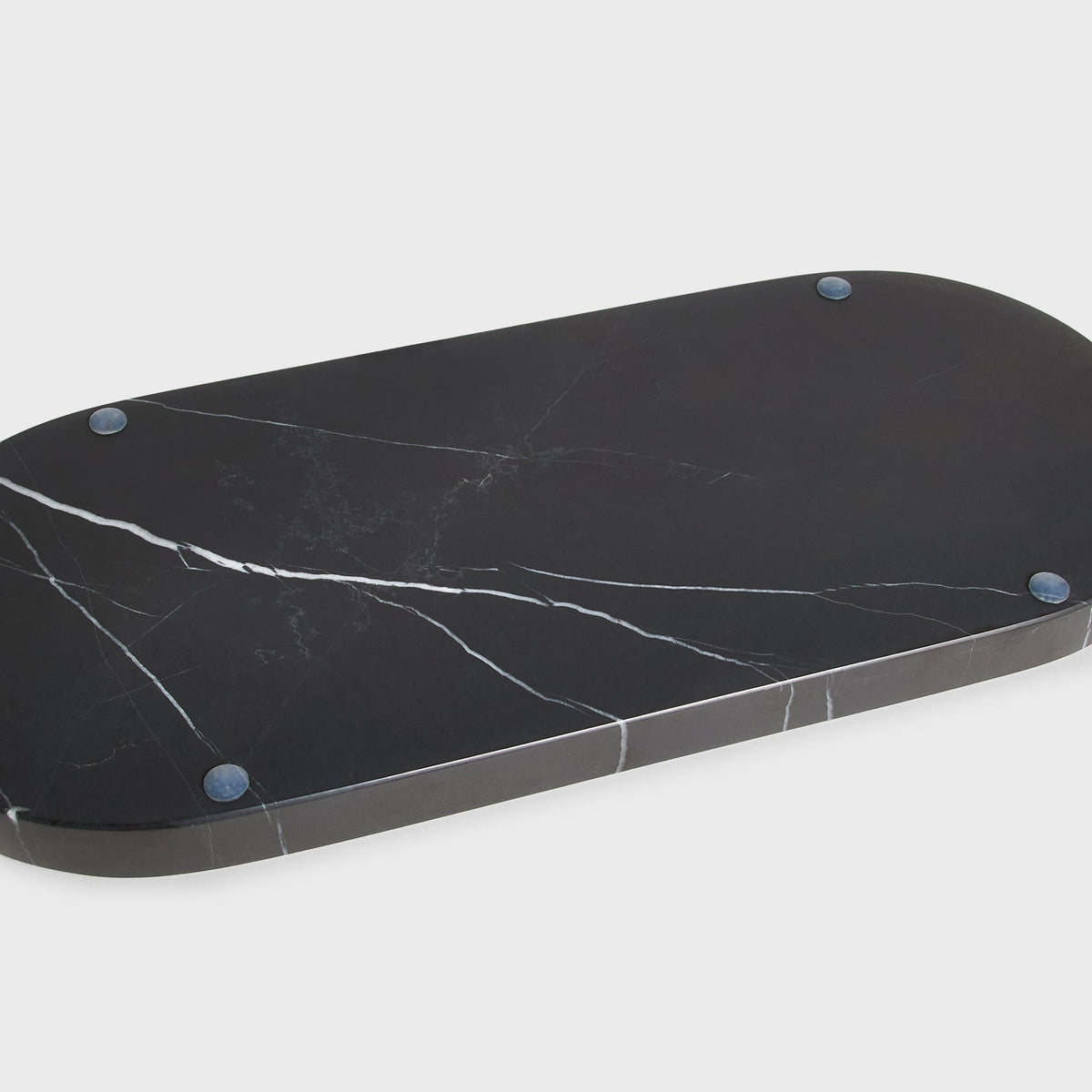 Close-up of underside of black Kith marble tray showing round feet